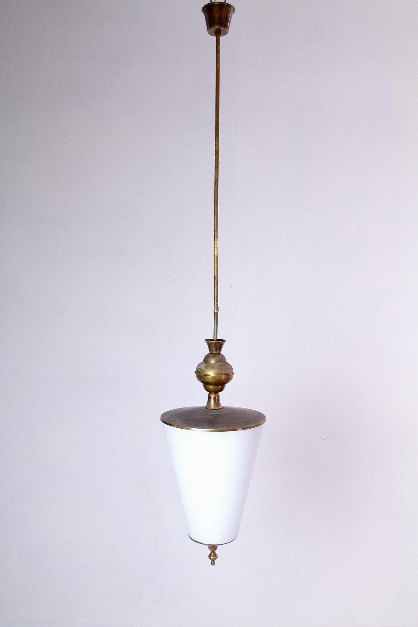 Une suspension élégante des années 1950 en laiton avec un abat-jour original en verre opalin. Le laiton est laqué sur les photos mais peut être poli sur demande bien sûr. La hauteur totale peut être réglée entre 130 cm et 60 cm.