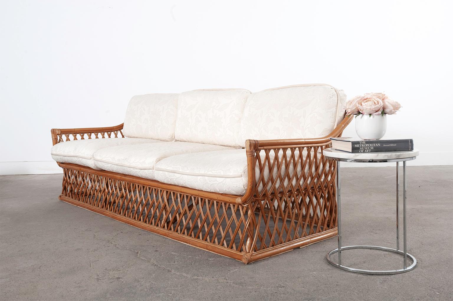 Grand Mid-Century Modern Italian bamboo rattan sofa made in the style and manner of Vivai Del Sud. The organic modern sofa is hand-crafted from bamboo and rattan. The bamboo frame features a geometric lattice woven design on the front, back, and