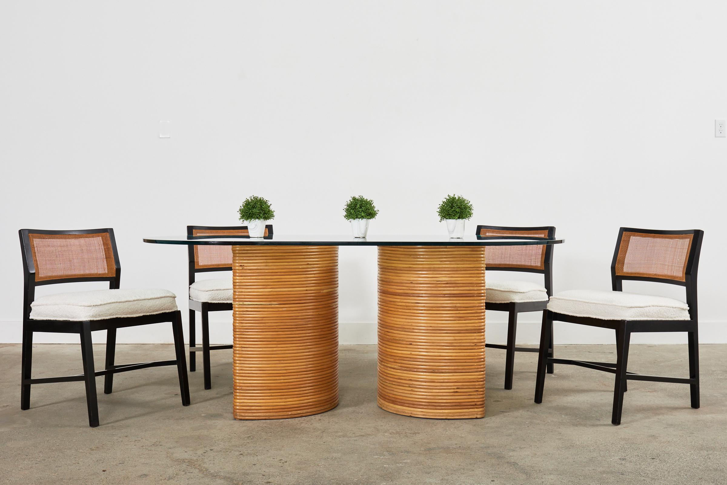 Fantastico tavolo da pranzo italiano a doppio piedistallo in stile Mid-Century Modern realizzato in rattan di canna spaccata. Il design moderno e organico è caratterizzato da piedistalli a forma di demilune o di 