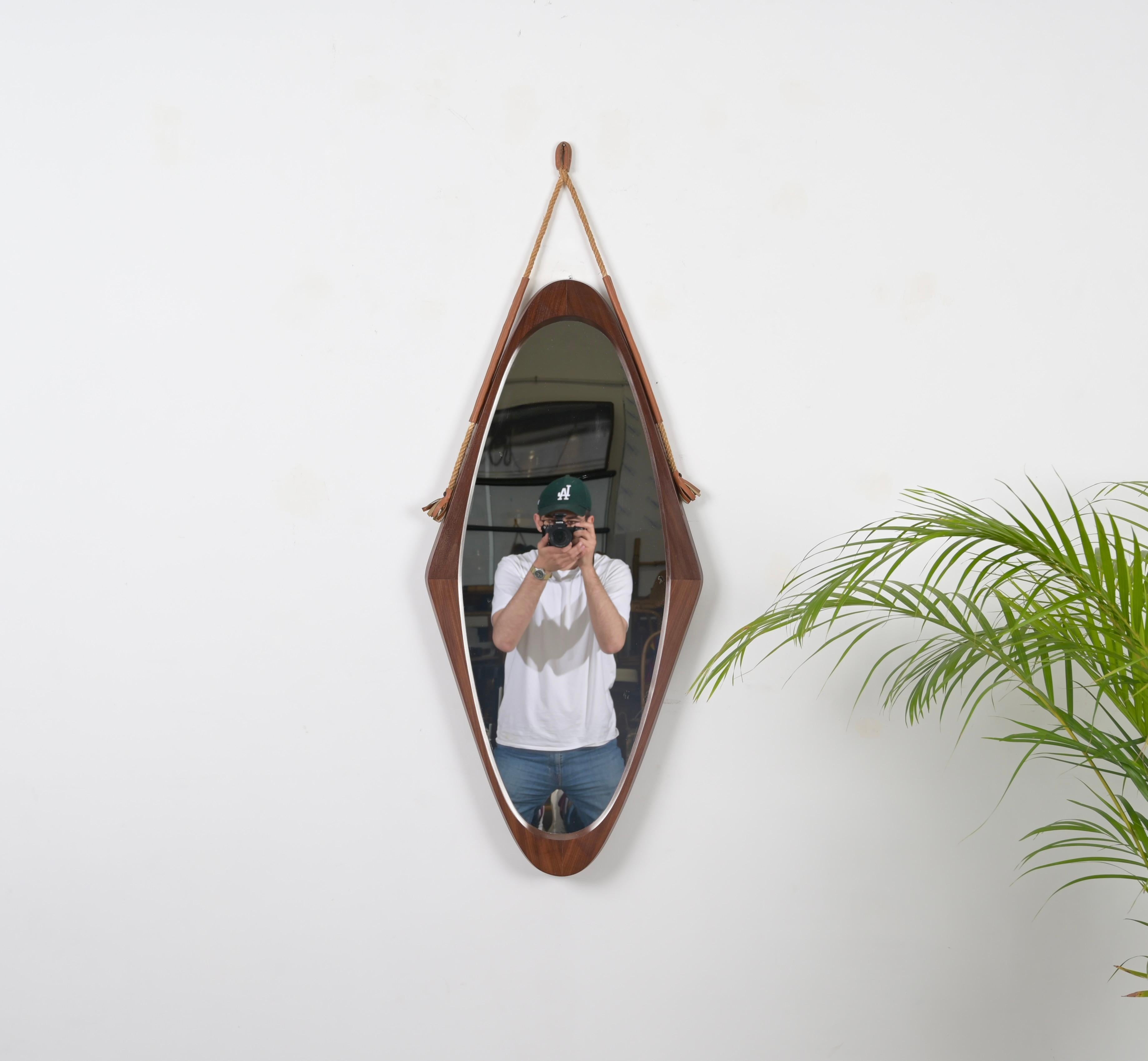 Gorgeous Mid-Century wall mirror in curved teak, rope and leather, this charming mirror was designed in Italy during the 1960s. 

This unique mirror features an astonishing oval shield-shaped frame made in curved teak wood with stunning grains, the