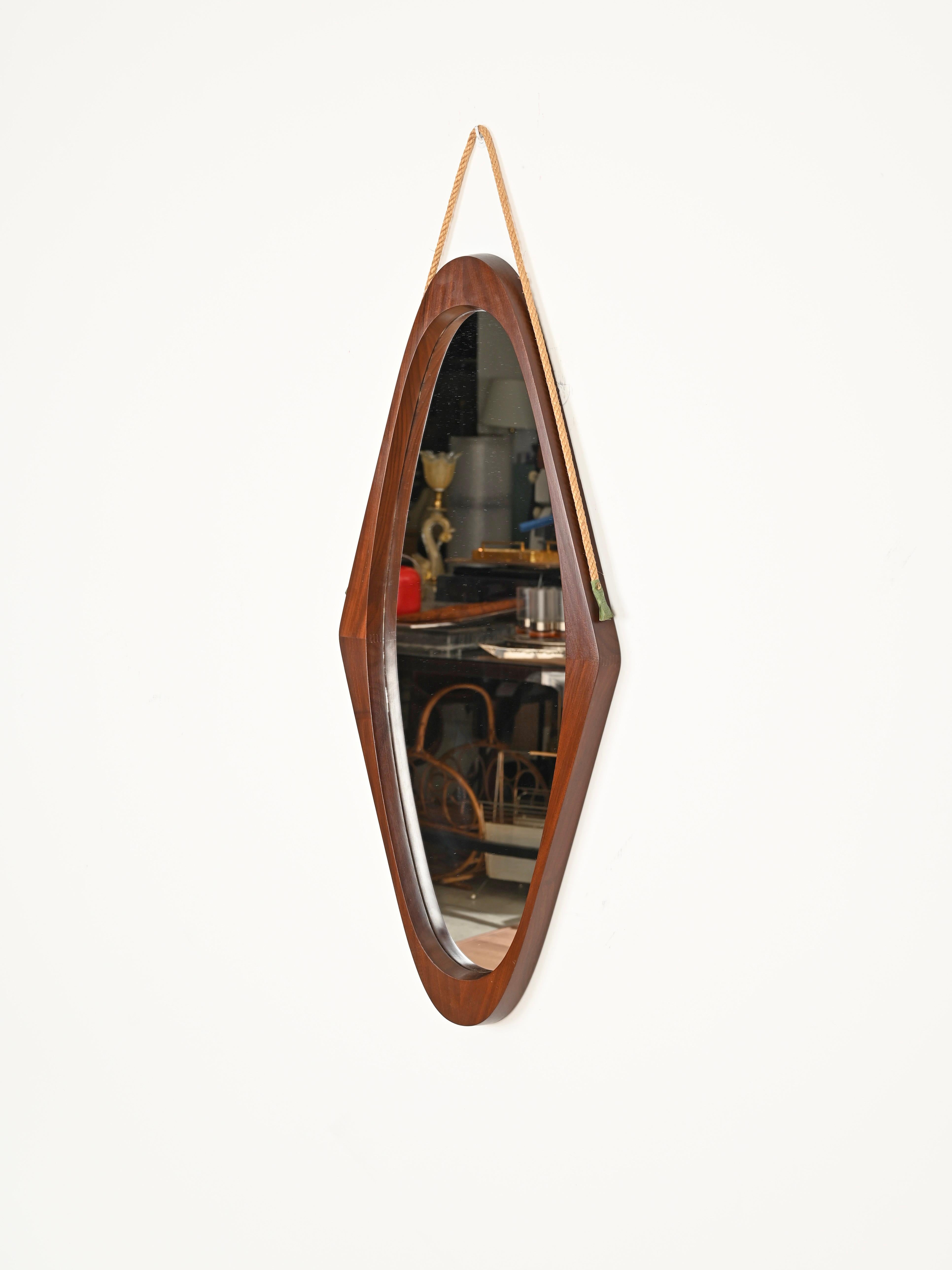 Merveilleux miroir en forme de bouclier datant du milieu du siècle dernier, réalisé dans un magnifique teck courbé et de la corde. Ce miroir au charme incroyable a été conçu en Italie dans les années 1960. 

En très bon état. Ce miroir unique