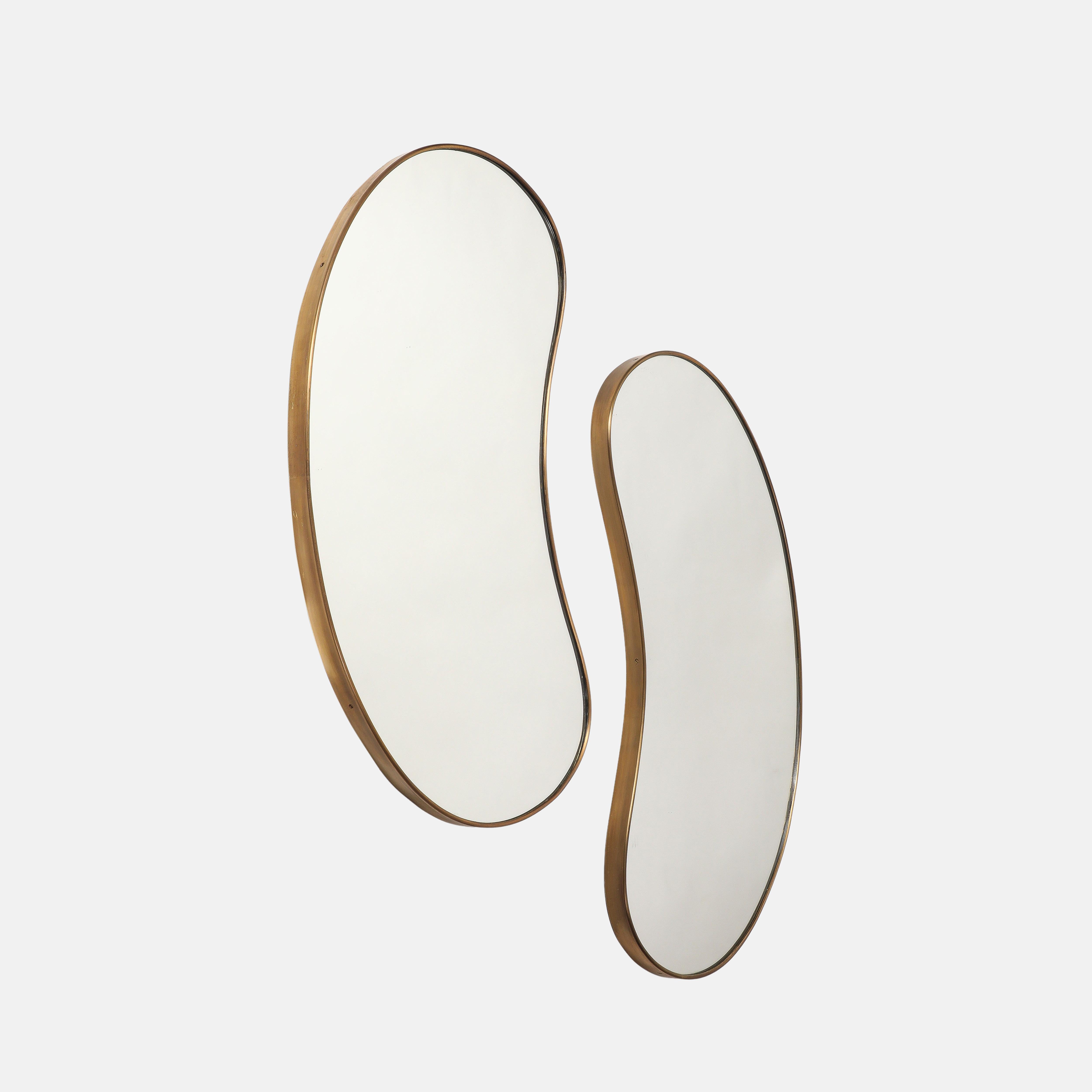 Midcentury Italian pair of kidney or bean-shaped brass wall mirrors, 1950s. These original midcentury period mirrors have a lovely organic curved form and a beautiful rich patina to the brass with solid wood backing. 