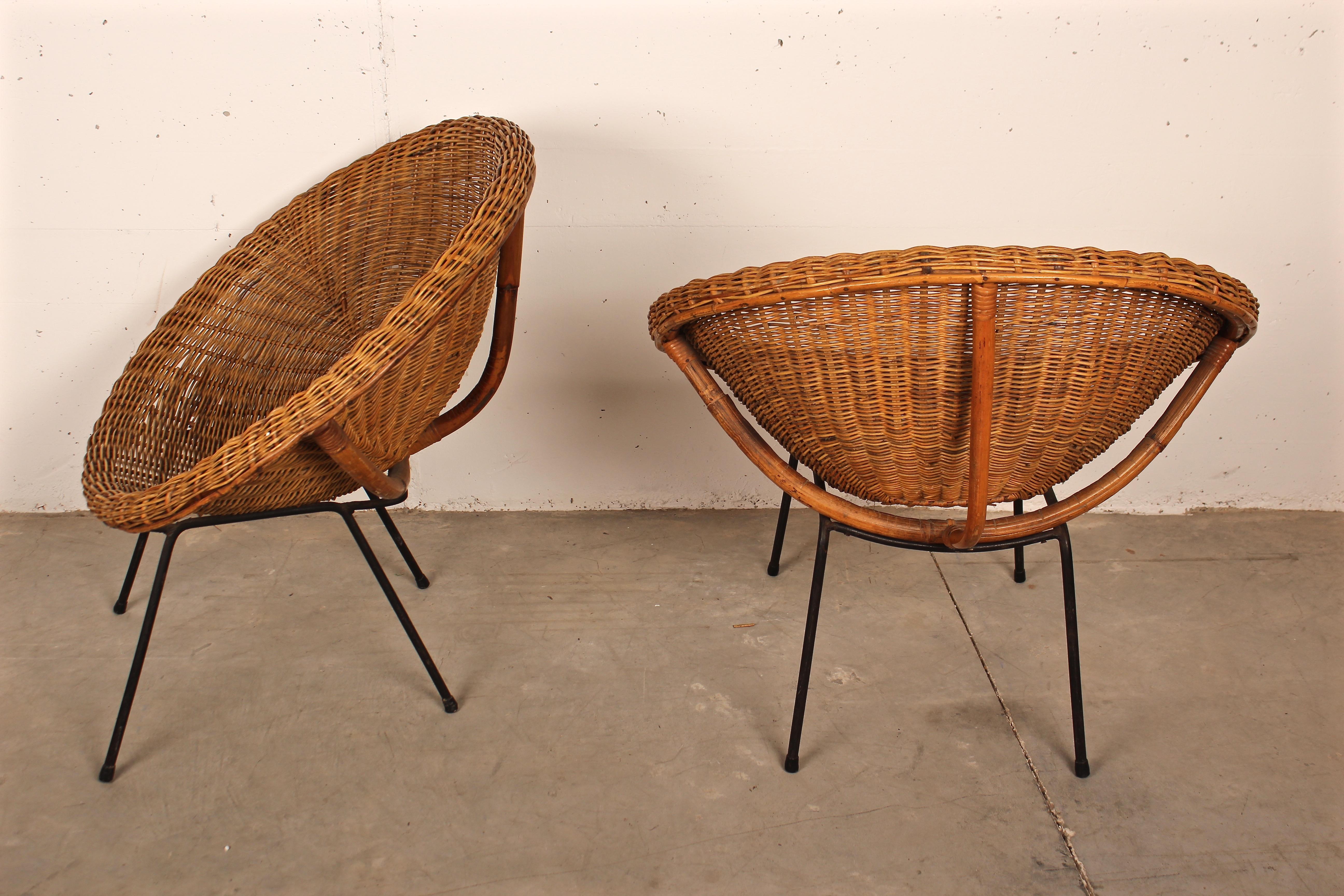 Pair of Italian 1950s armchairs in the shape of a circle in woven wicker rattan and bamboo the legs are in black lacquered metal.