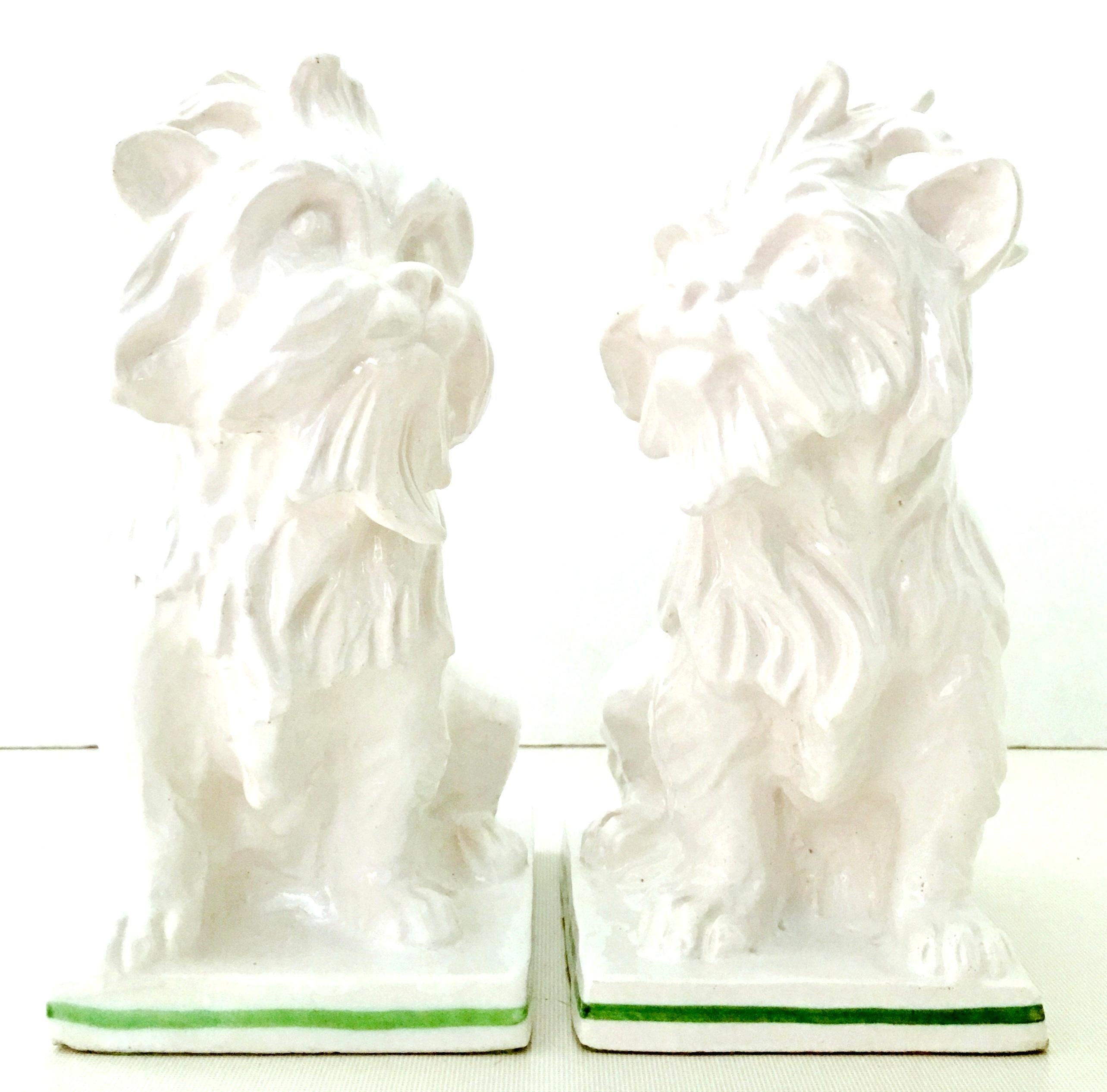 Mid-20th century Italian pair of ceramic glaze Staffordshire Style white with green piping detail terrier dog sculptures-Italy. Each piece is signed on the underside felt, Italy.