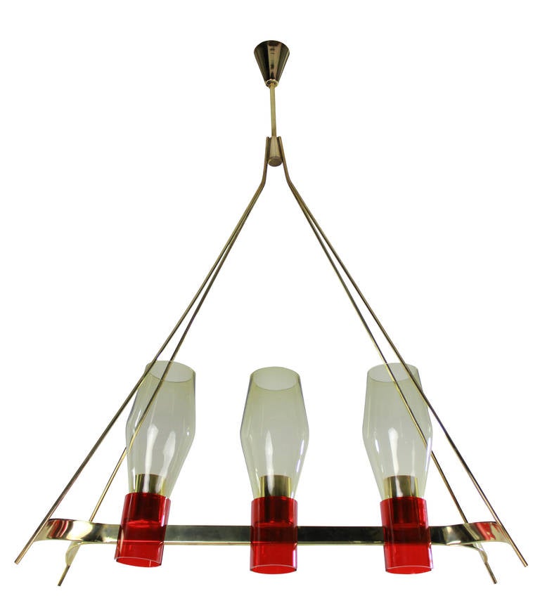 An Italian hanging light of unusual design, in brass with red detailing and pale yellow glass shades..
 
   