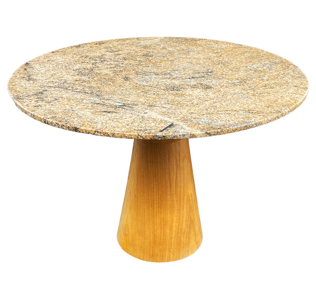 A contemporary Italian dining table from Italy circa 1990's. It features a heavy circular granite top with a birch wood base. Very good ready to use condition.
