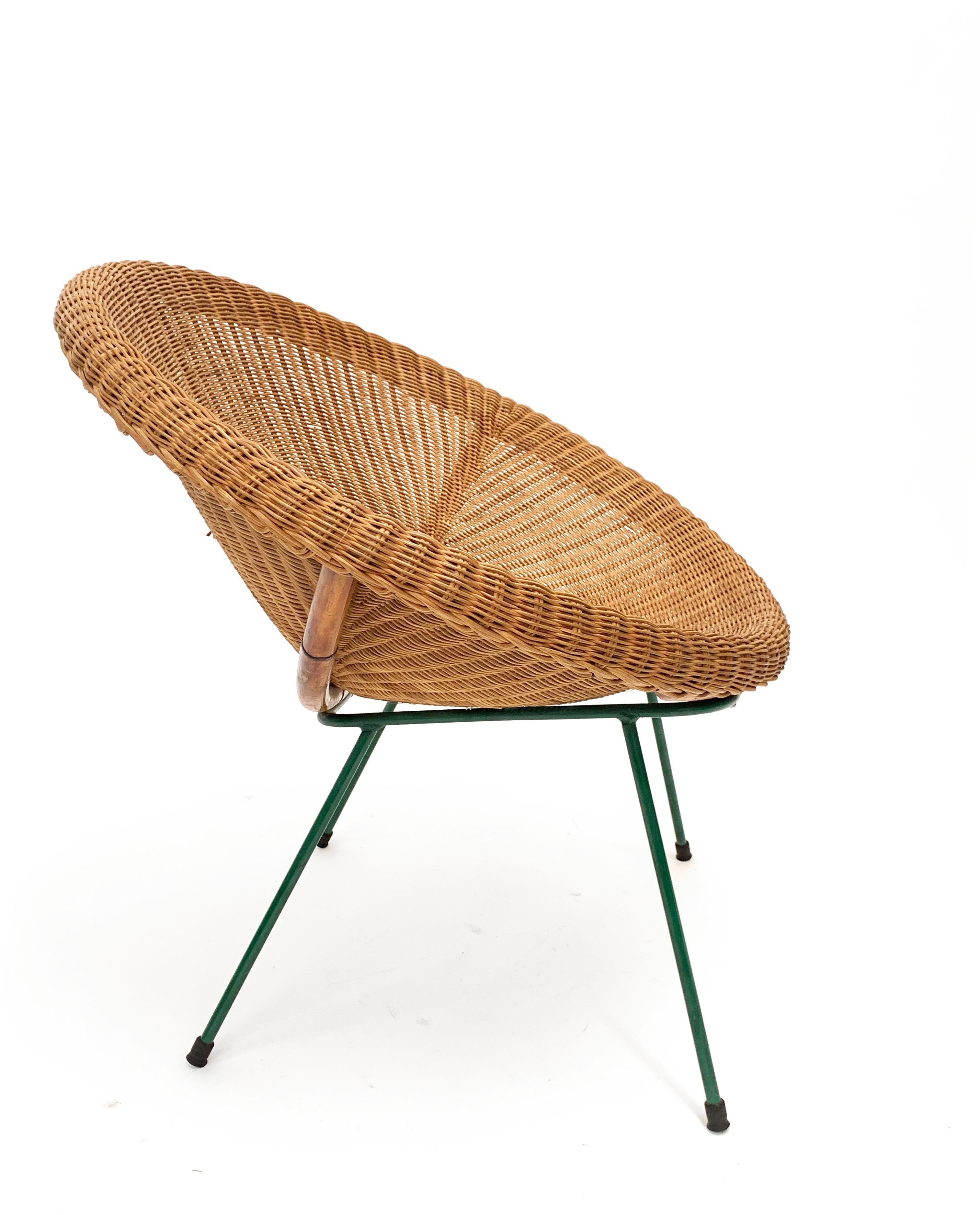 Amazing midcentury rattan and bamboo shell armchair with lacquered green metal legs. This wonderful piece was produced in Italy during 1950s.

This item is very elegant as it has a simple bamboo structure with a peculiar rattan seat lying on thin