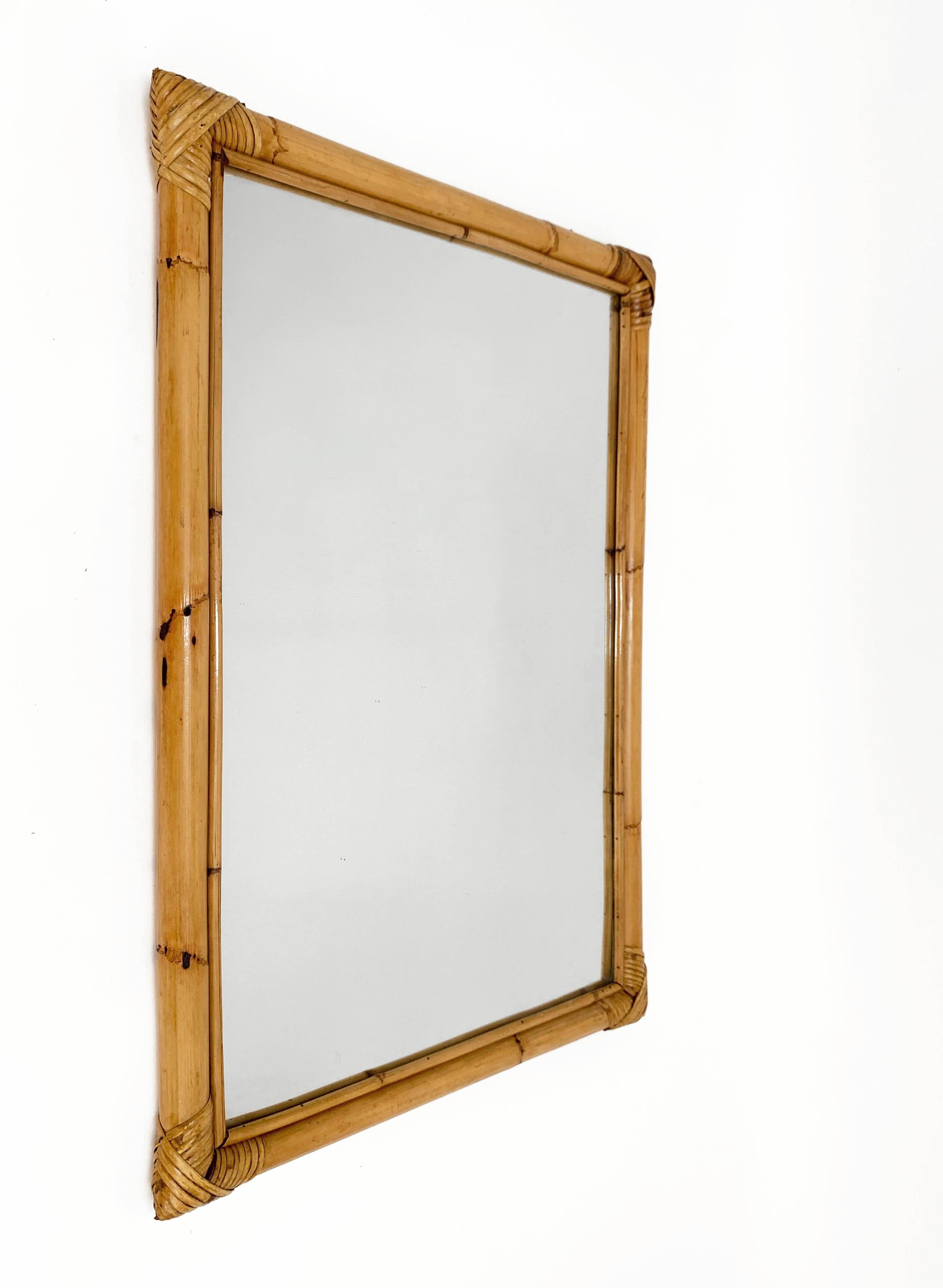 Wonderful midcentury rectangular mirror with bamboo woven wicker frame. This amazing item was produced in Italy during the 1970s.

The way in which bamboo lines and glass integrate is superb and transmits to this mirror a neverending