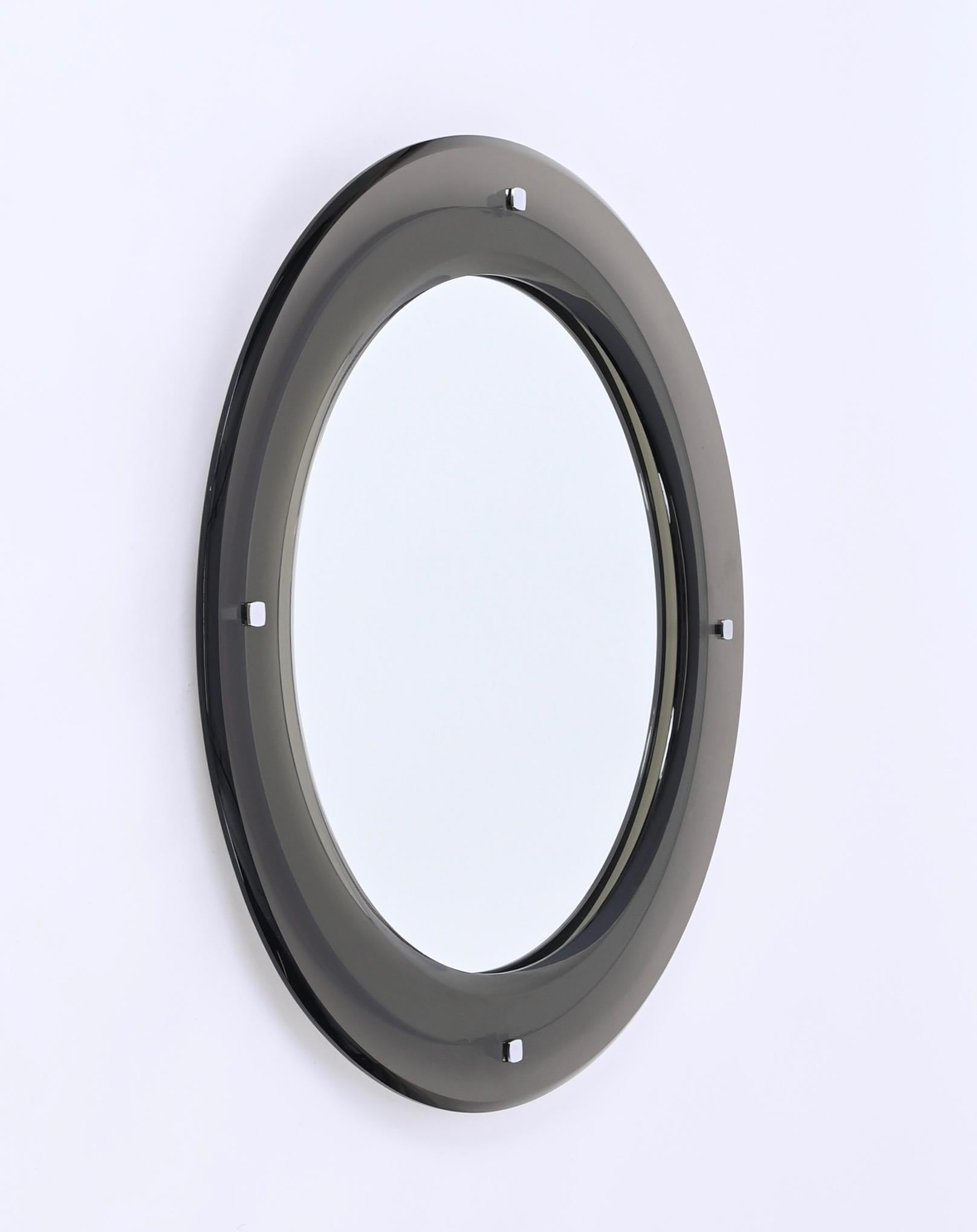 Gorgeous round mirror with double bevelled frame in smoked glass produced by Sena Cristal in Italy in Italy in the 1970s.

This fantastic space age mirror features a stunning frame with two large bevels in smoked glass that changes color depending