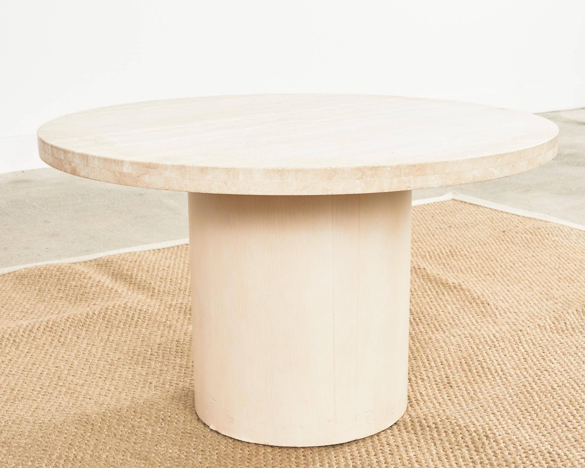 Dreamy Mid-Century Modern Italian cocktail or coffee pedestal table featuring a 1.5 inch thick round travertine top. The travertine has a creamy white and beige veining and is mounted on top of a round wooden pedestal base with a cream colored