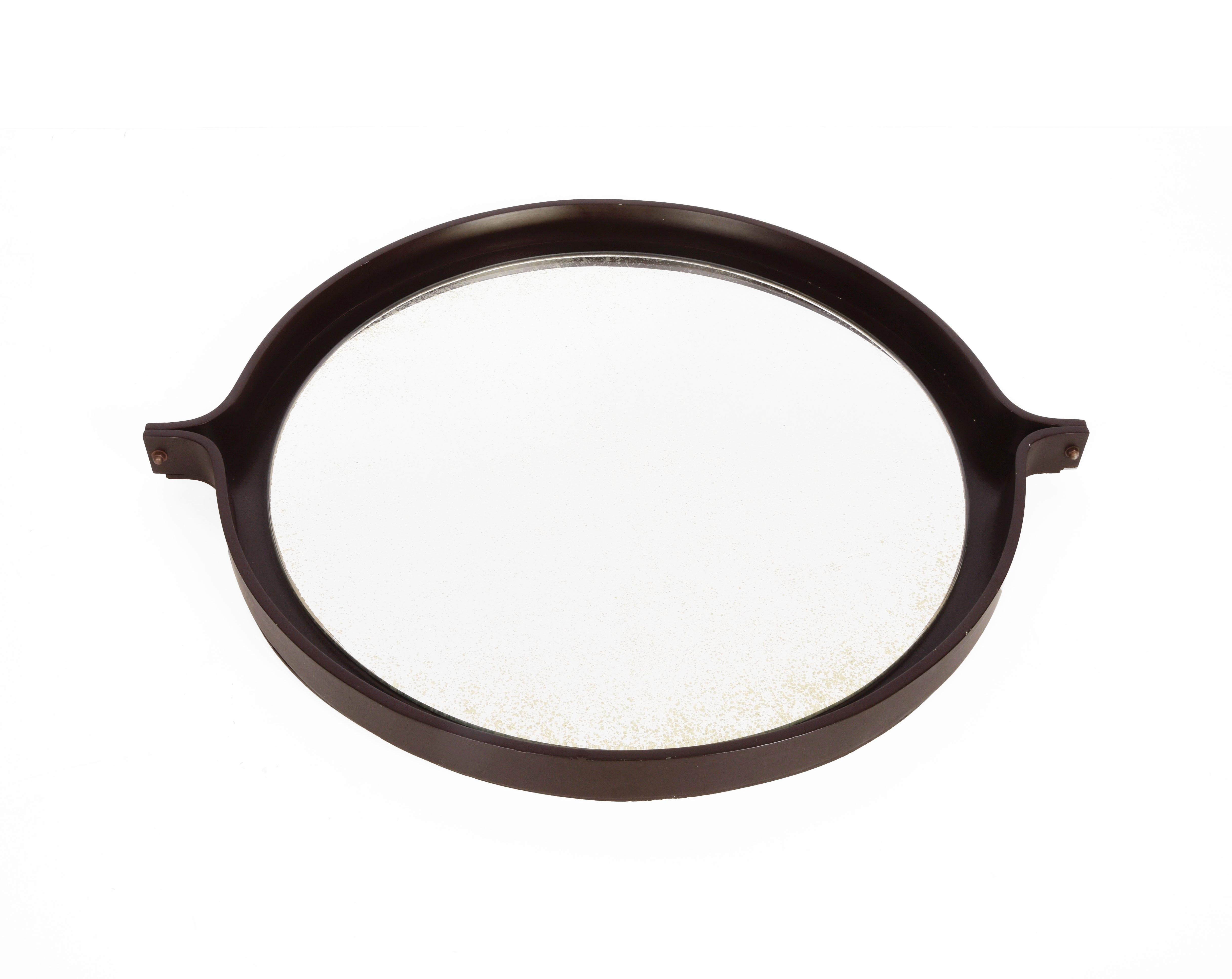 Amazing round dark brown wood mirror. This item was produced in Italy during the 1960s.

This wonderful piece is very elegant and timeless because of the simplicity of the materials and the midcentury lines.

The perfect element to enrich a