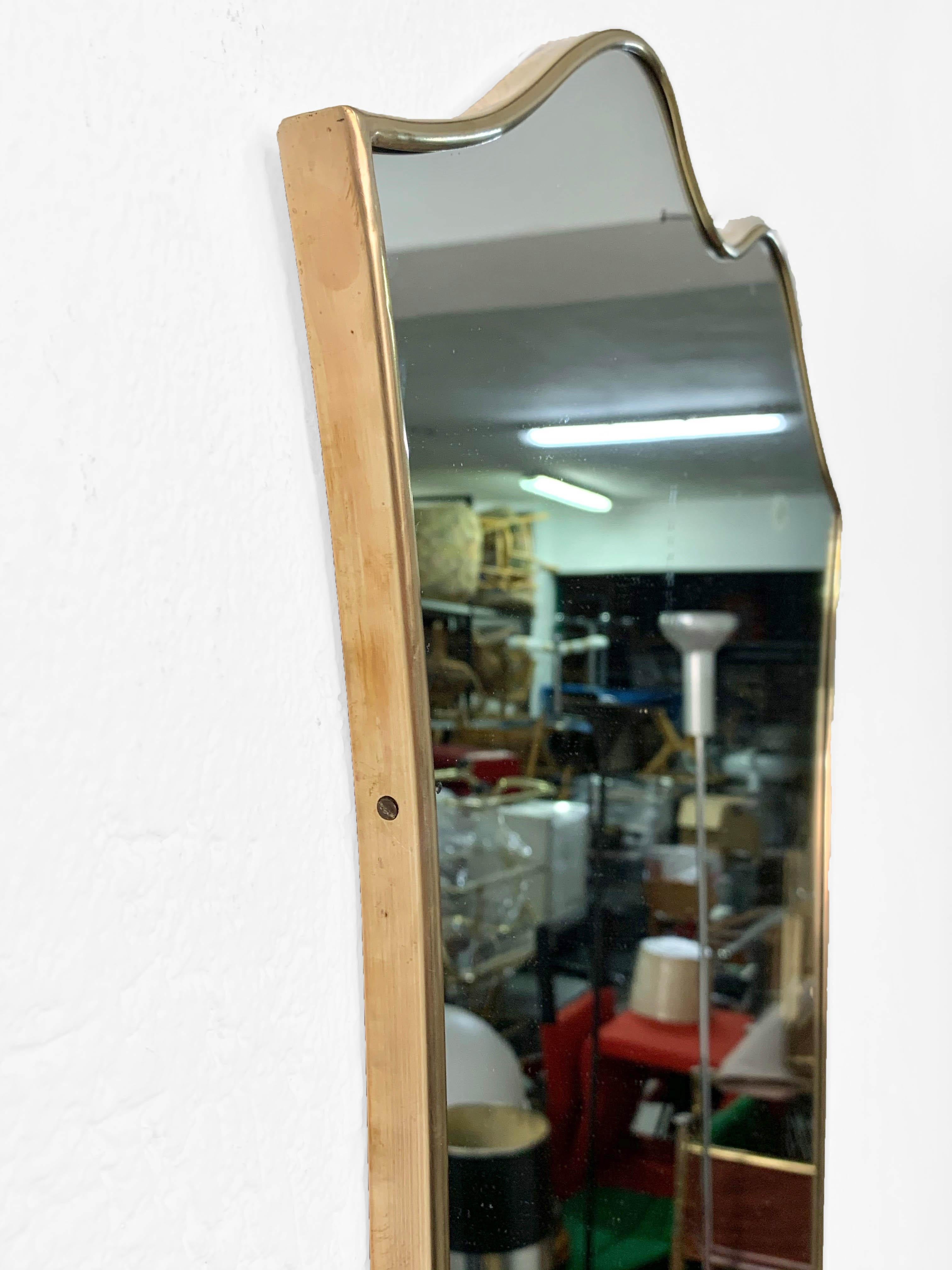 Amazing midcentury mirror attributed to Gio Ponti. This iconic piece has a shield-shape and a very elegant and light brass frame. 

The item has an original sticker, dated 10th February 1961 and indicating the producer, the famous 