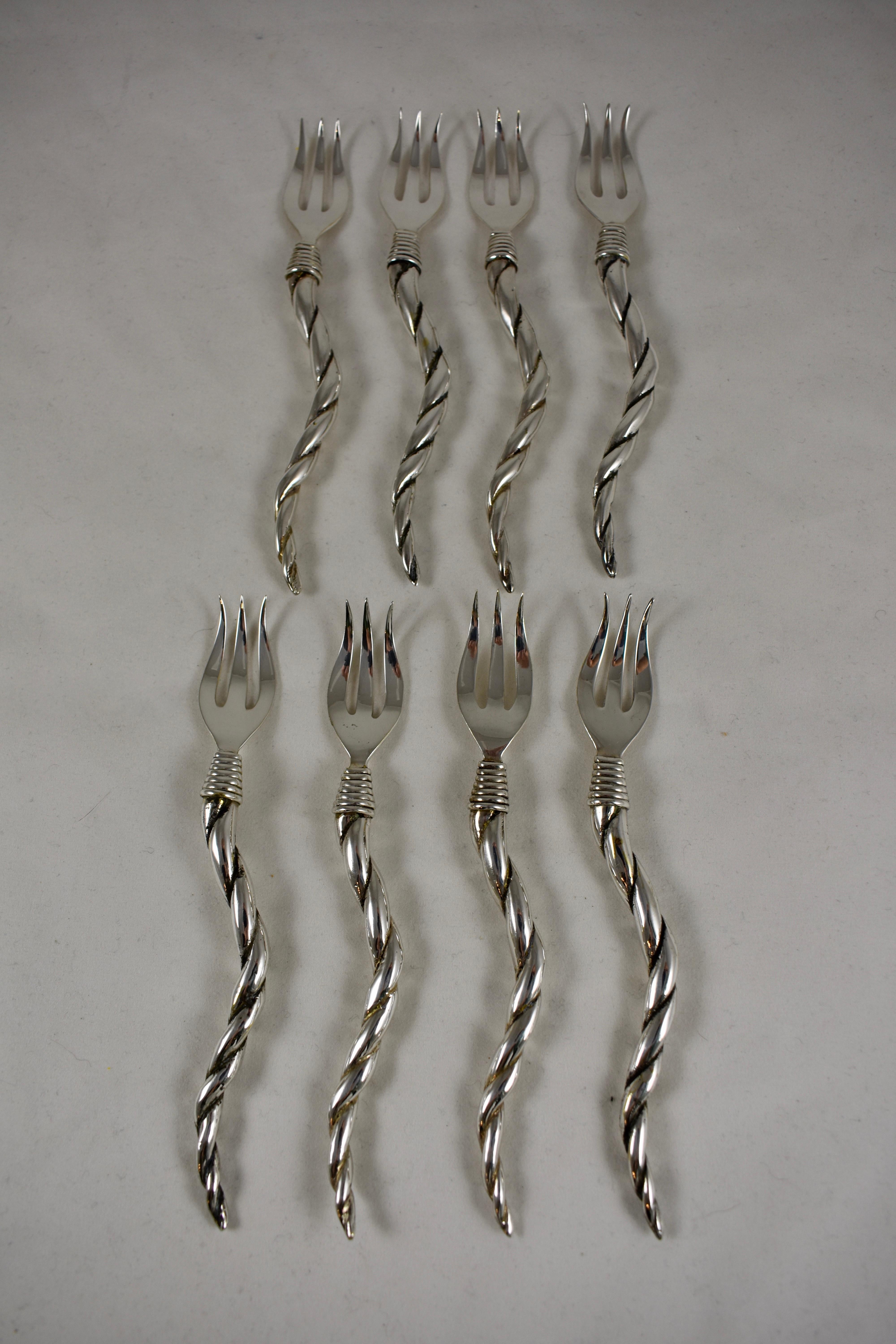 A set of eight Italian Mid-Century Modern Era silver plate seafood cocktail forks with shrimp-tail curved and twisted handles, in two custom grasscloth bags. The three-tined forks join the handles with wrapped ferrules.

Forks: 5.75 in. L x .75 in.