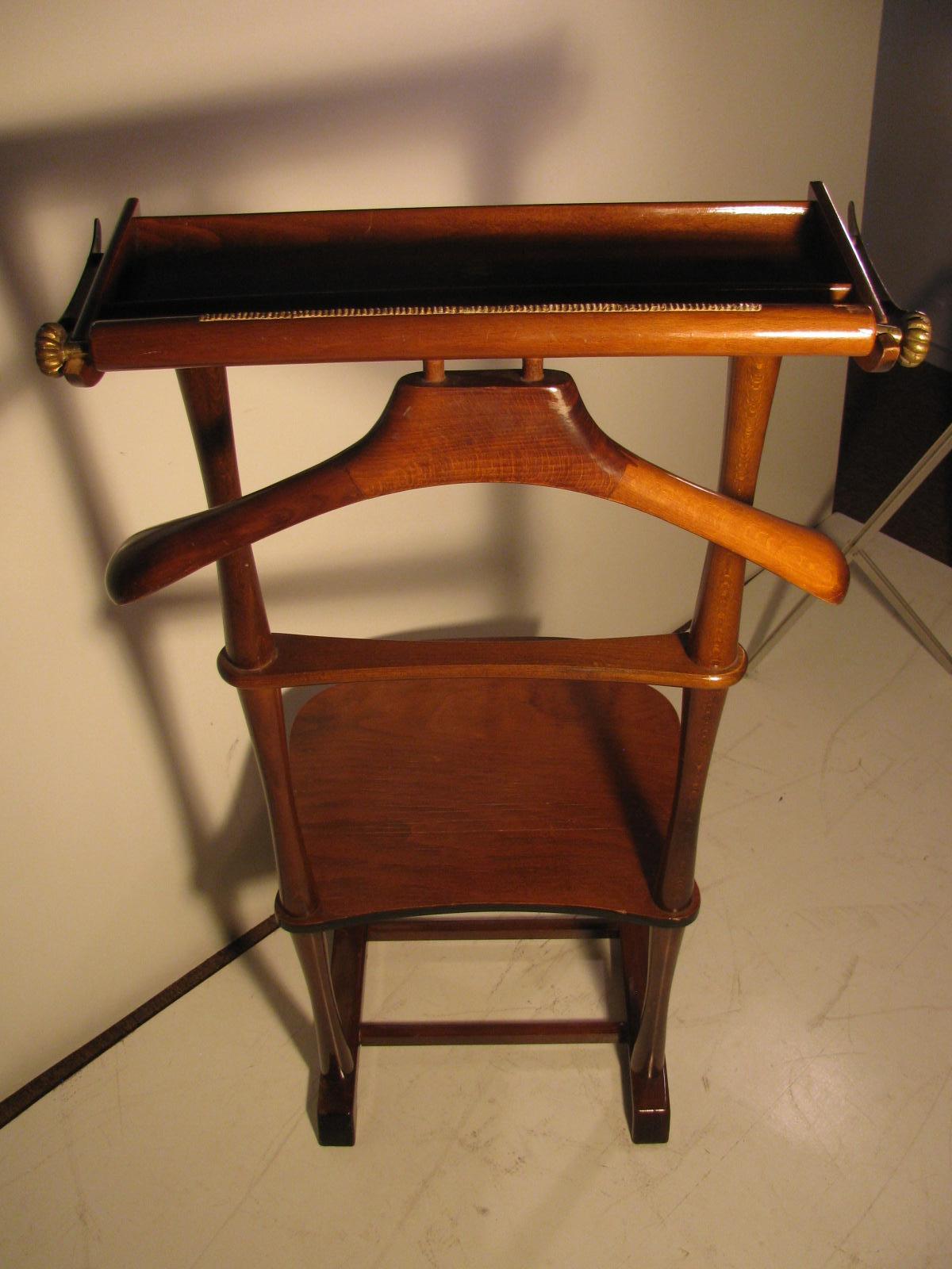 Mahogany clothes valet from Italy. Seat with a pullout drawer, upper jacket and pants rack along with a change and jewelry tray. Measures: Seat height is 15.