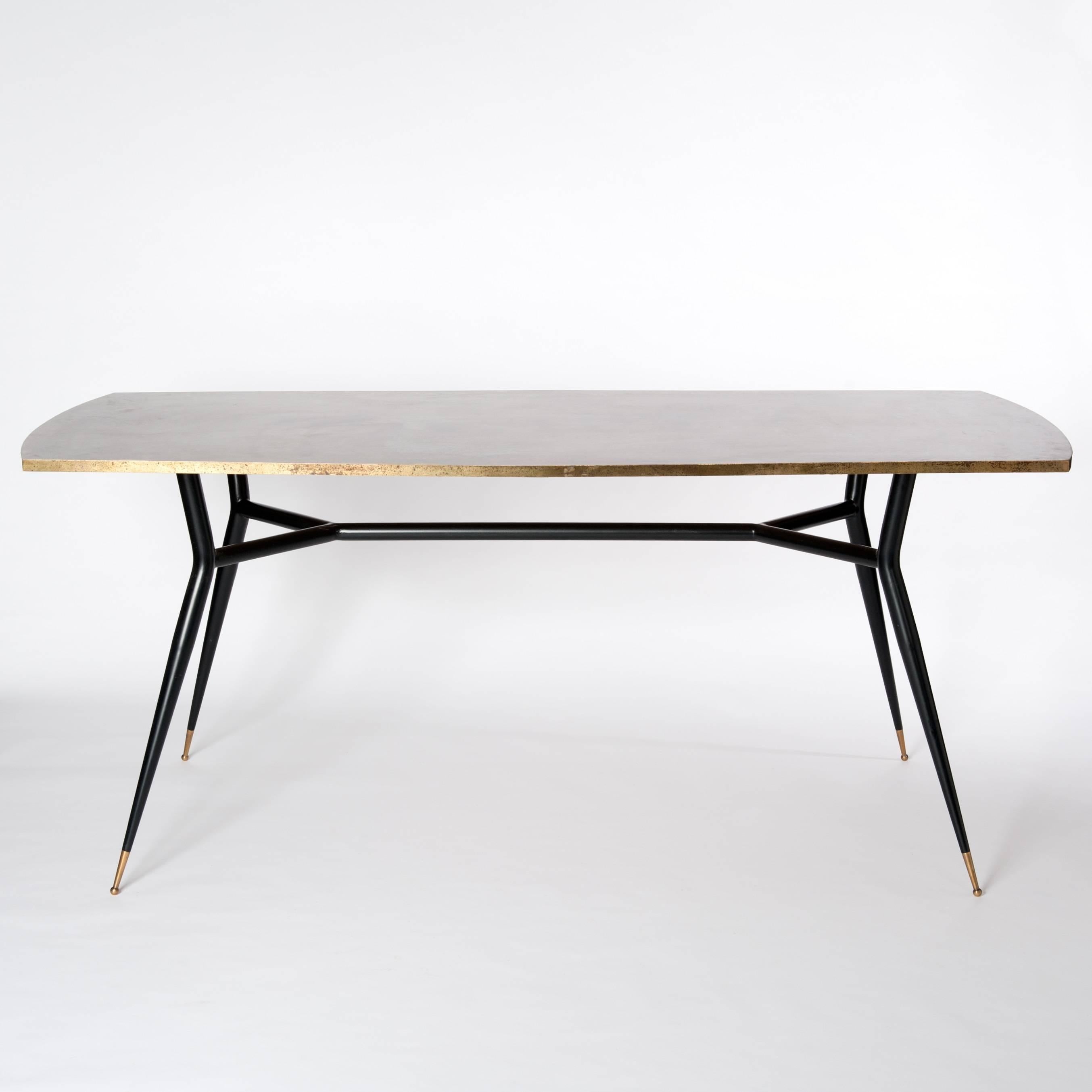 Grazile Italian dining room table or writing desk, four tapered black iron sputnik legs with bronze trimming.
The extraordinary shaped wooden table top is veneered by bronze fixed on a matt finish iron base.
The top shows an exceptional patina in