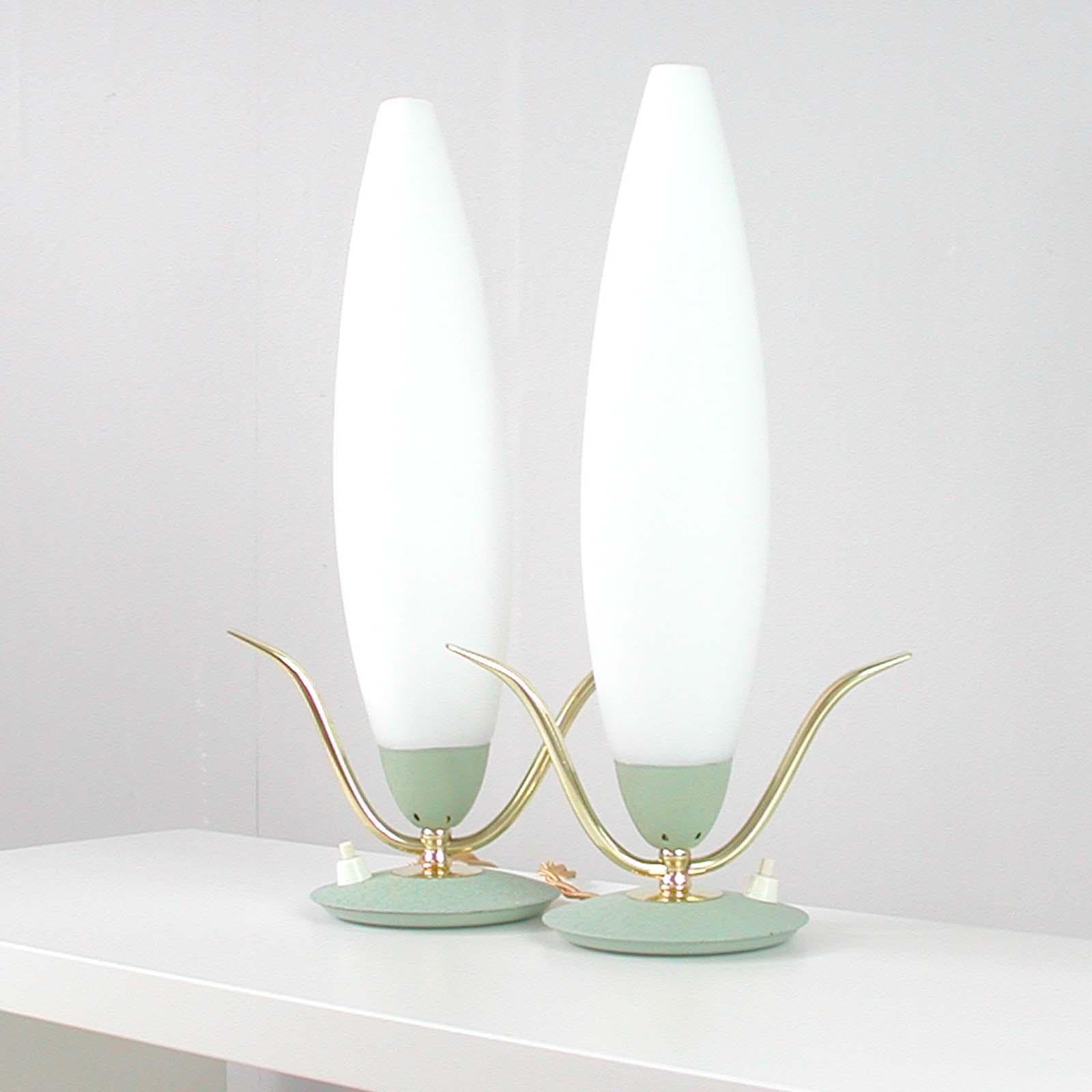 Cet ensemble de 2 lampes de table a été fabriqué en Italie dans les années 1950. 

Les lampes sont réalisées en métal et laiton laqué vert menthe clair et ont des abat-jour en verre opalin de style fusée.

Les lampes ont été polies, recâblées et