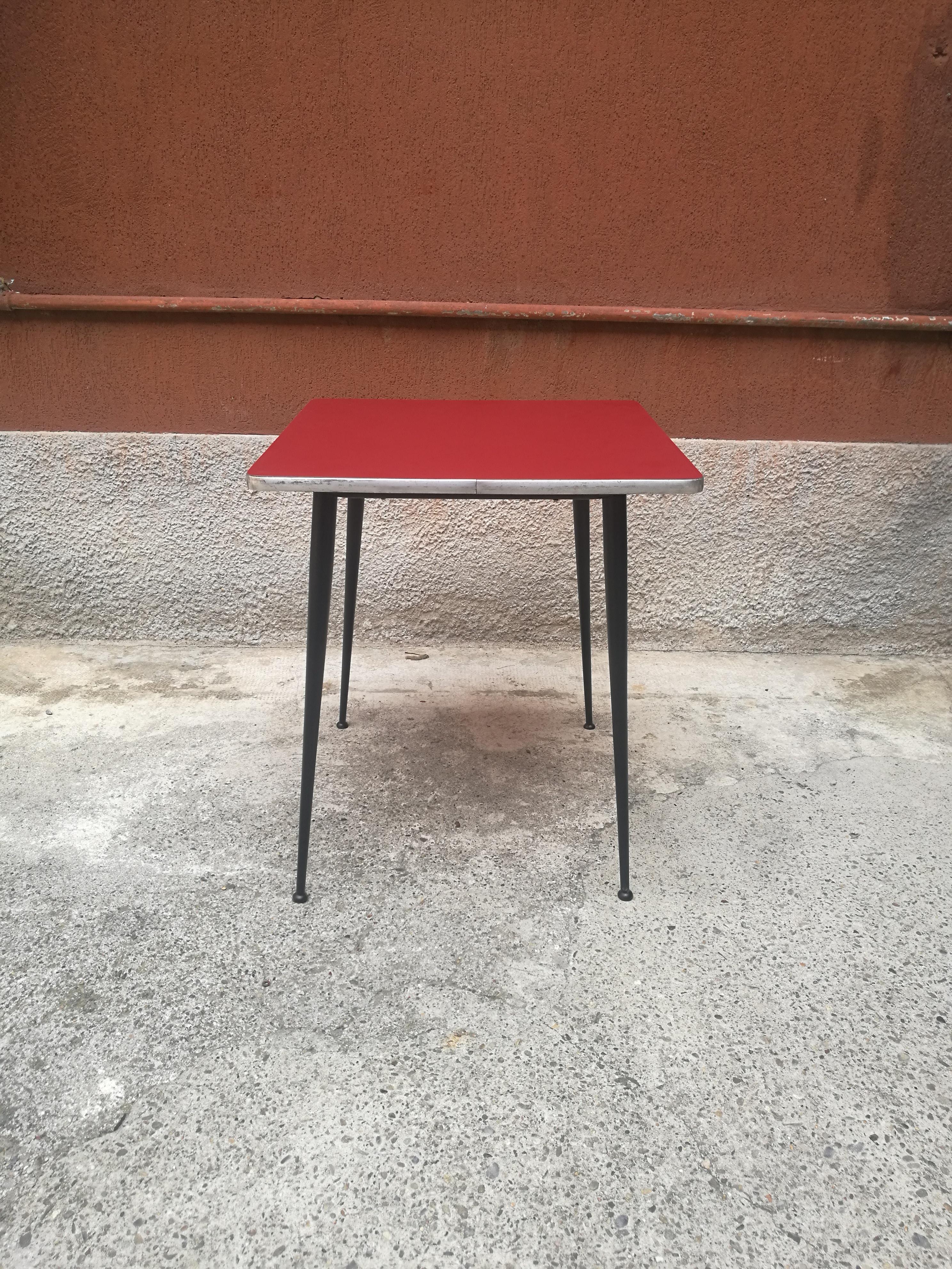 Midcentury Italian squared red formica ad metal table from 1960s
Table of Italian production, from 1960s, with red formica table top, chromed on the border, with four black metal legs. The dark red and the rounded angles diversify a kind of
