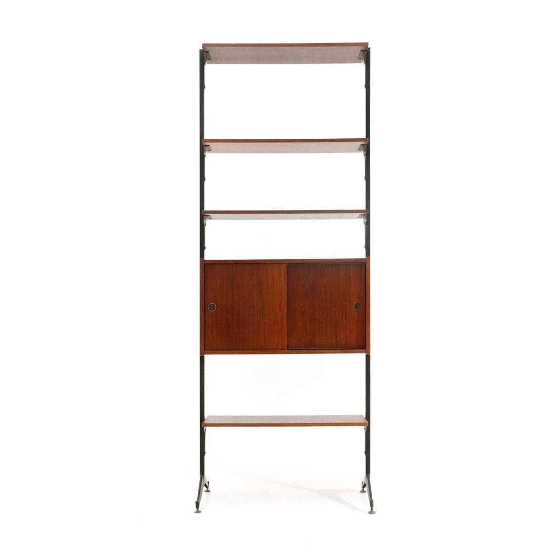 Italian manufacture bookcase produced in the 1960s.
Uprights in black painted metal and brass feet adjustable in height.
Storage compartment and shelves in teak veneered wood.
Storage compartment with sliding doors and plastic handles.
Good