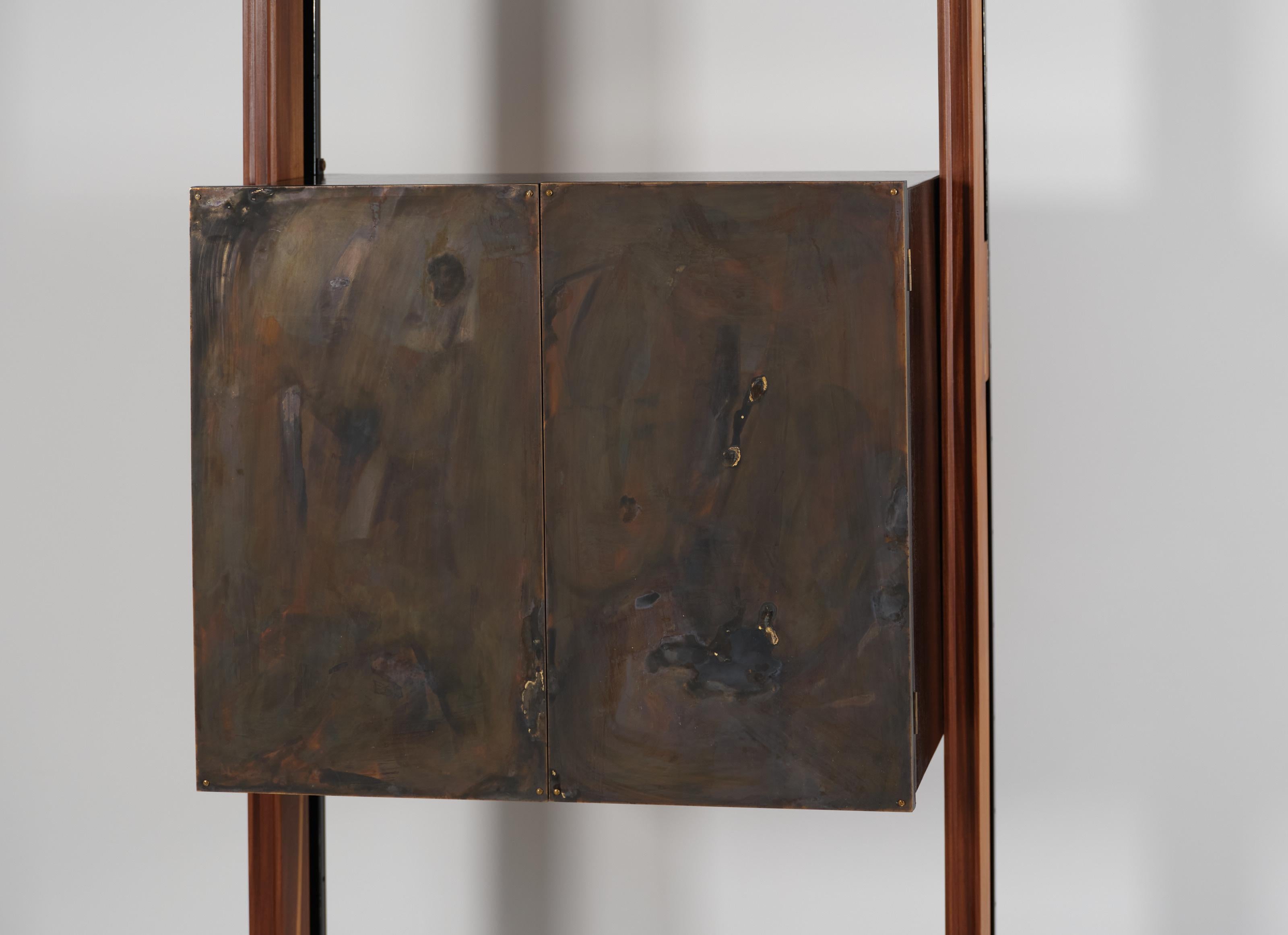 Crafted from the finest teak wood, this modular Wall Unit features a sophisticated system of pressure mounting between the floor and ceiling, ensuring stability and adaptability to any space. The combination of teak wood and iron creates a