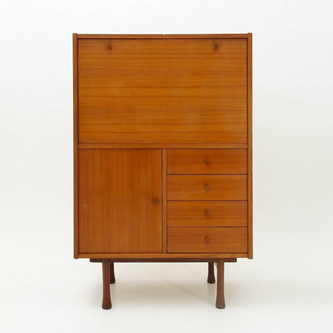 1960s Italian sideboard.
Teak veneered wood structure.
Drawers, flap compartment and storage compartment with wooden handles.
Wooden legs.
Structure in good condition, some shots and missing veneers visible in the picture.

Dimensions: Width
