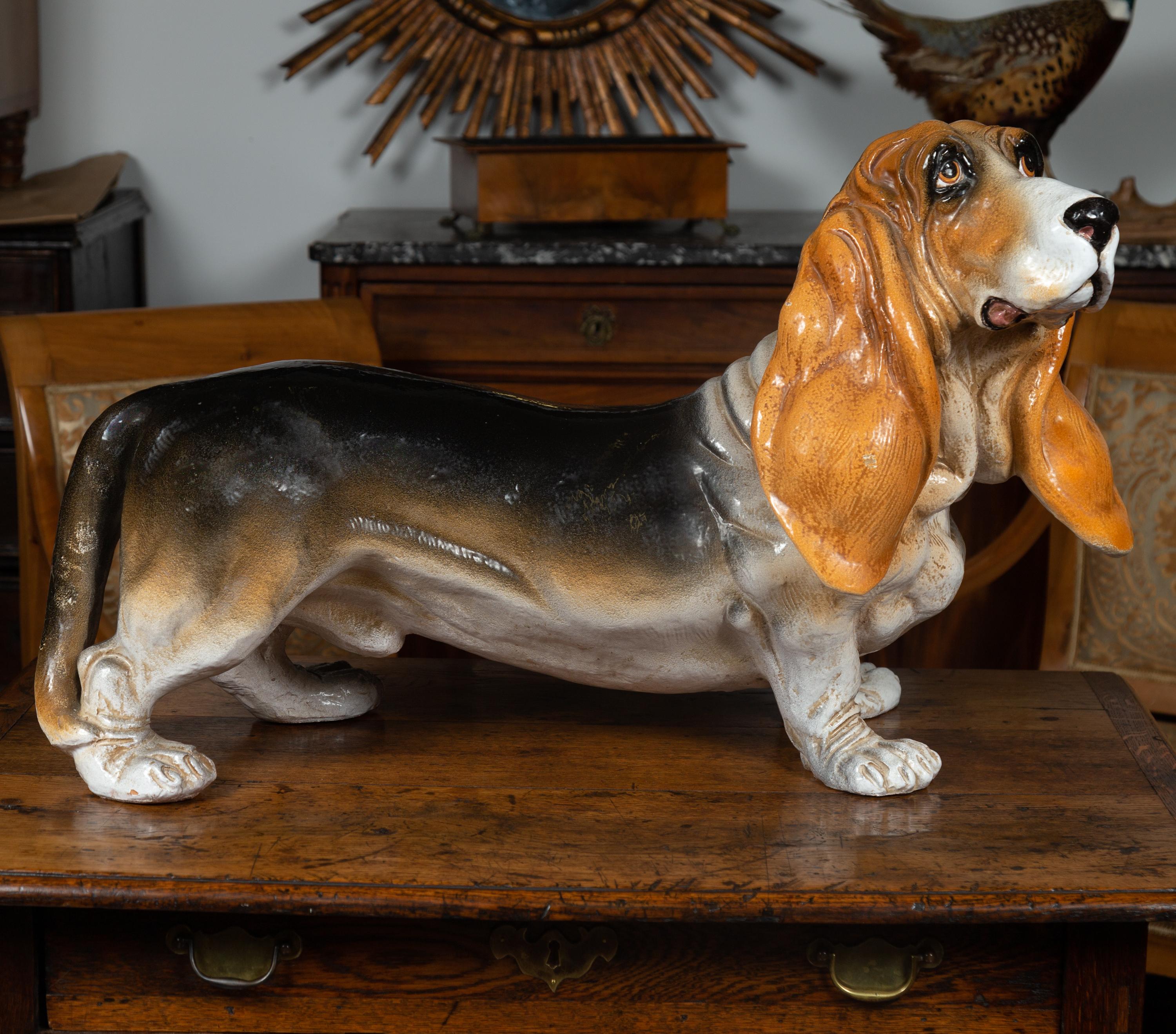 A vintage Italian terracotta basset hound sculpture from the mid-20th century. Born in Italy during the midcentury period, this charming terracotta sculpture depicts a basset hound standing on his four paws and gazing upward. Boasting lovely russet,