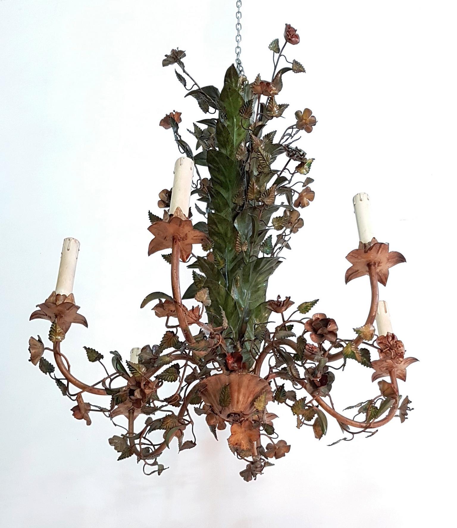 Chandelier from the 1950s made from iron and painted with a natural vintage patina. It has six candle lights surrounded with flowers leaves in different shapes and colors. It is in working condition but we recommend rewiring as it’s the original