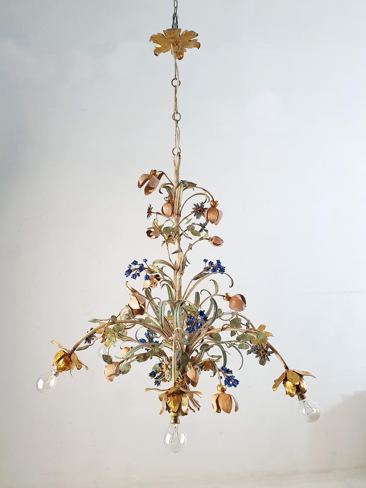 Chandelier from the 1950s made from iron and painted with a natural vintage patina. It has six candle lights surrounded with flowers leaves in different shapes and colors. It is in working condition but we recommend rewiring as it’s the original