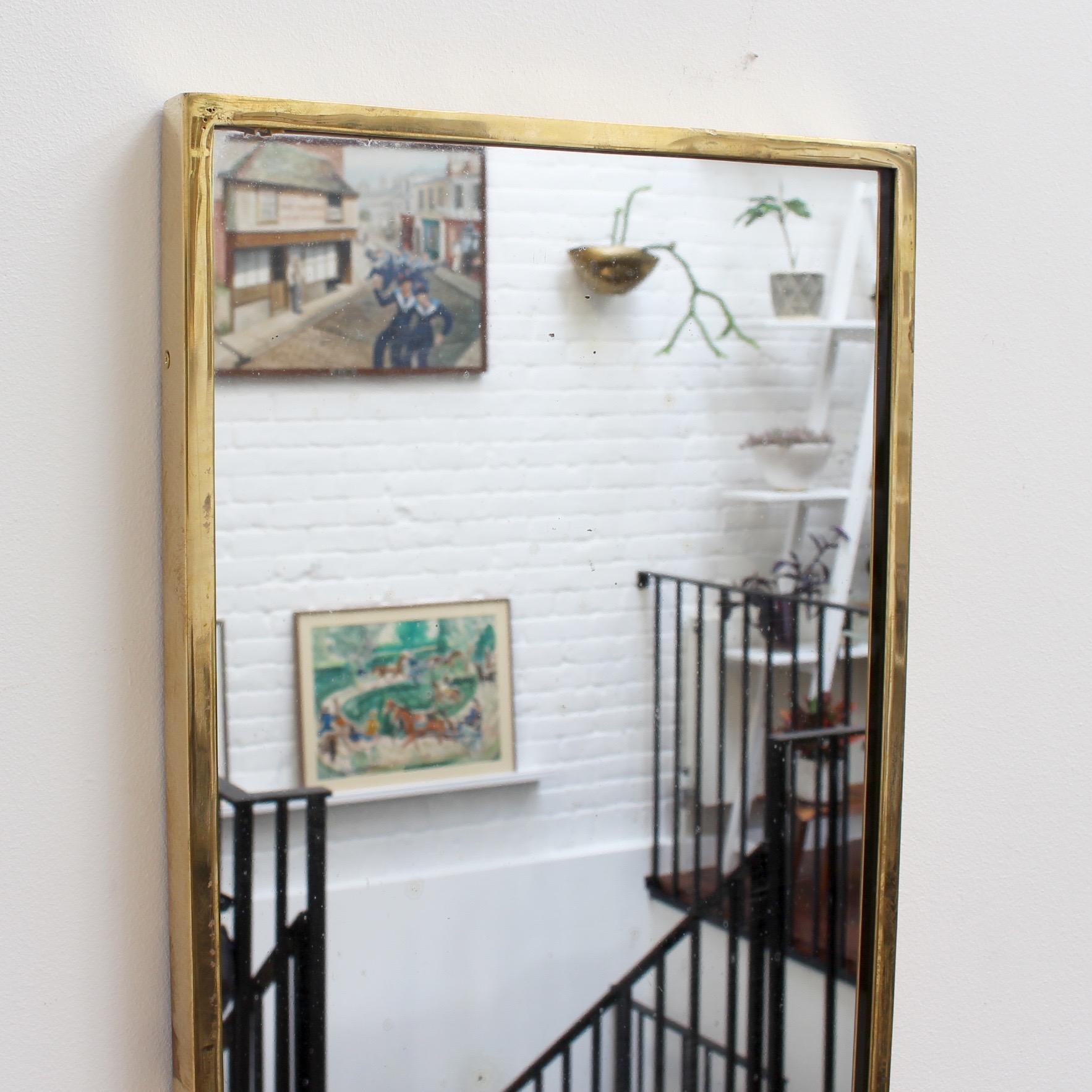 Italienischer Wandspiegel aus der Mitte des Jahrhunderts mit Messingrahmen, ca. 1950er Jahre. Der Spiegel ist wappenförmig - klassisch elegant und unverwechselbar im modernen Gio Ponti-Stil. Dieser Spiegel ist in sehr gutem Vintage-Zustand. Der
