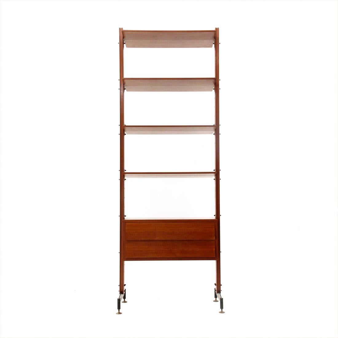 Italian-made bookcase produced in the 1950s.
Wooden uprights with black painted metal support system.
Height adjustable feet in brass.
Chest of drawers and shelves in veneered wood.
Shelves with tapered edges.
Good general condition, some signs