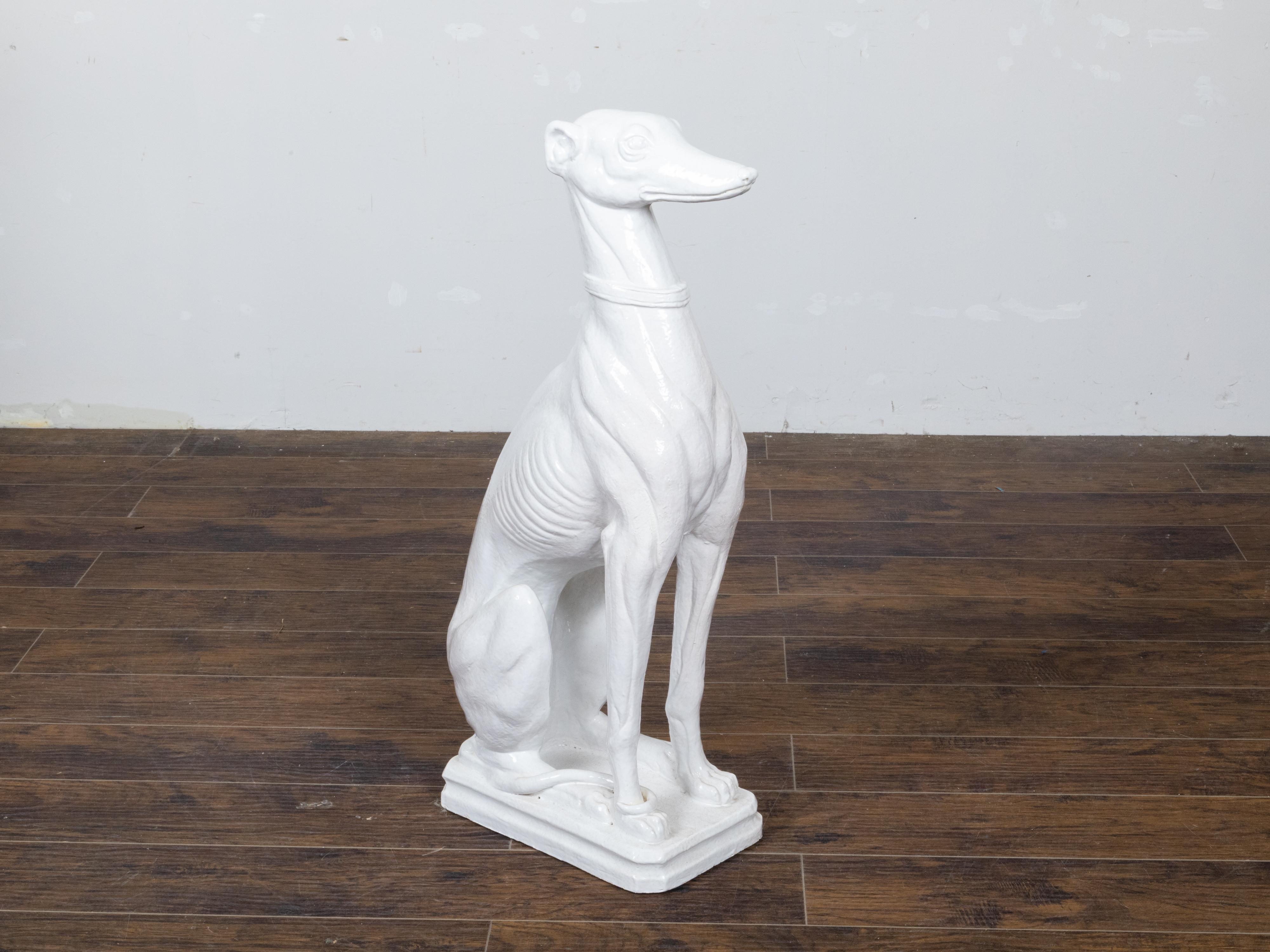 A vintage Italian Midcentury white porcelain sculpture depicting a greyhound dog sitting obediently on his behind. Lend an air of elegance to your space with this vintage Italian Midcentury white porcelain sculpture, artfully depicting an obedient