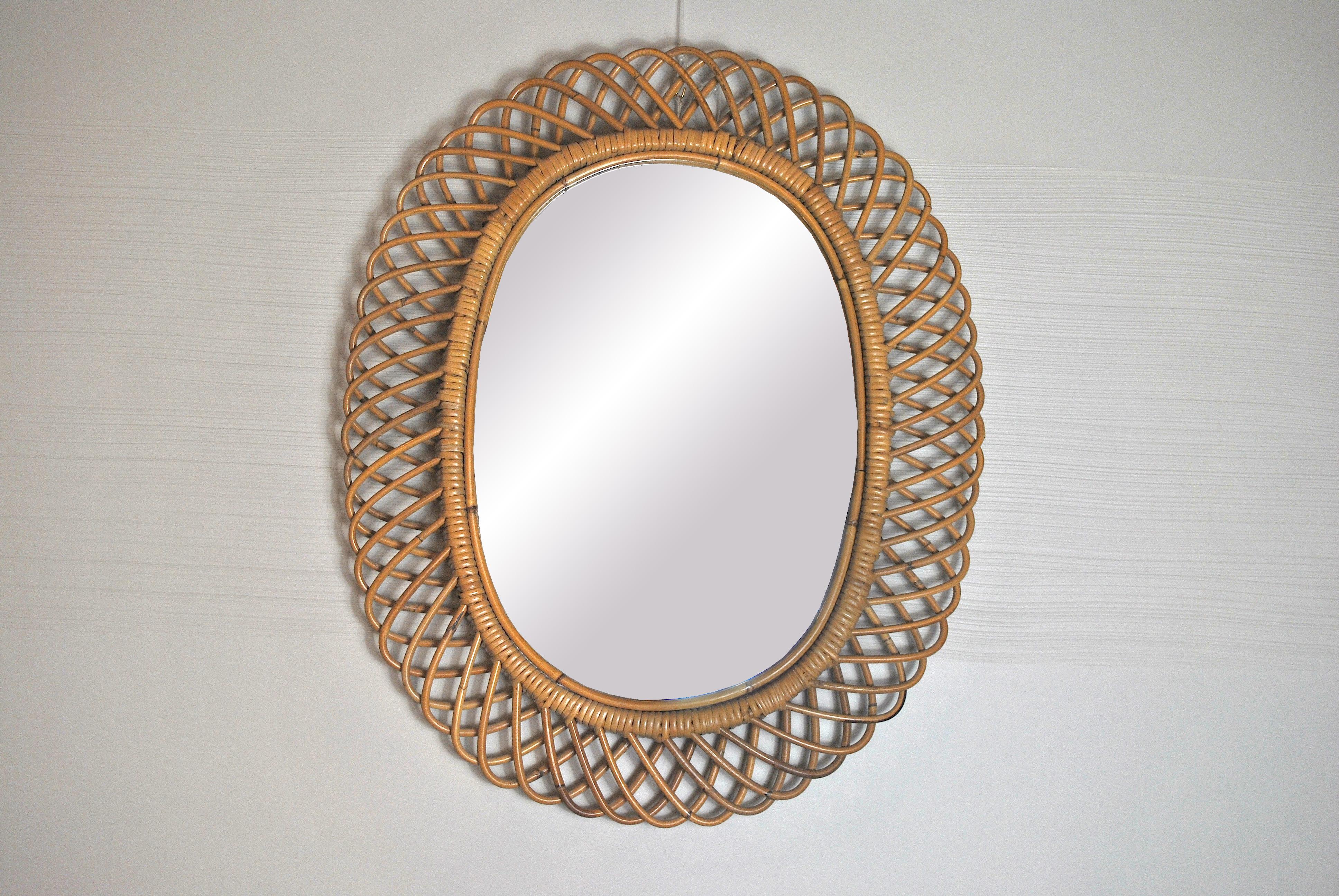 Midcentury wicker and bamboo oval mirror in the style of Franco Albini in very good condition.