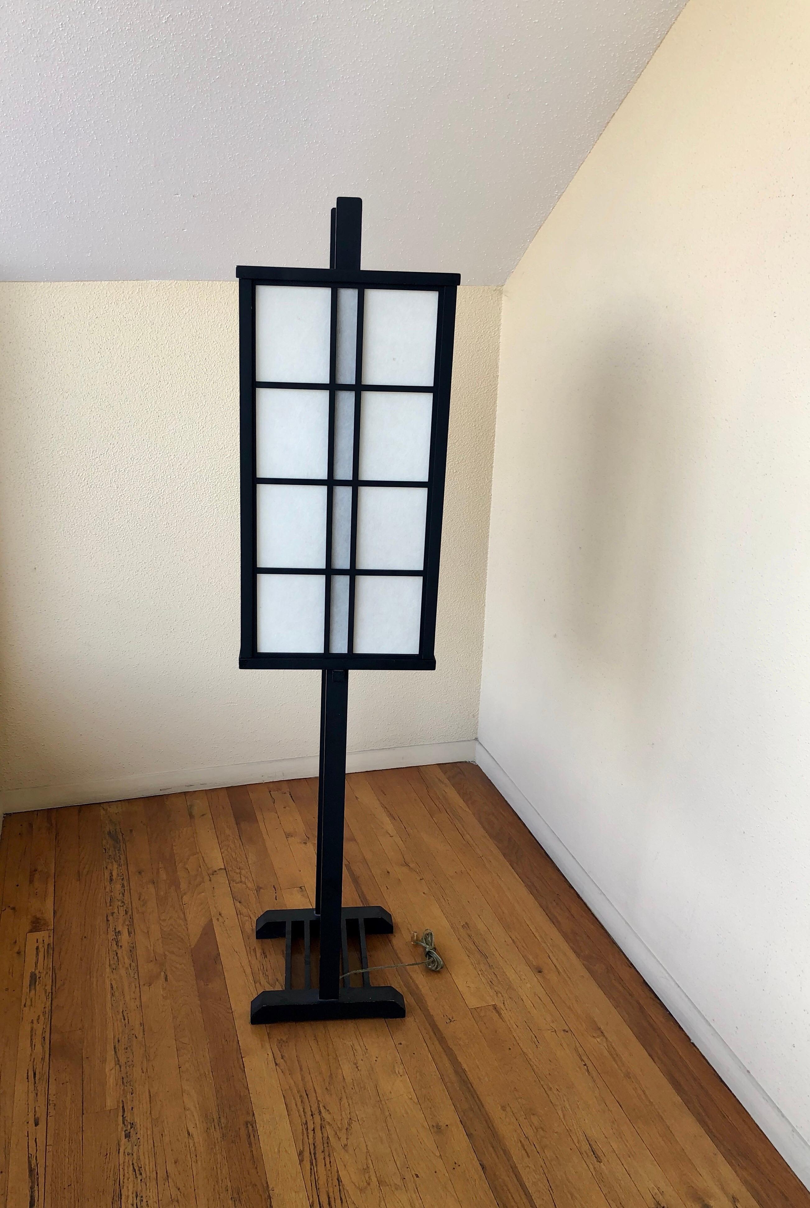 Minimalist Japanese lantern floor lamp. Black lacquer Wood frame with removable rice paper shade, circa 1970s. Nice condition and working.