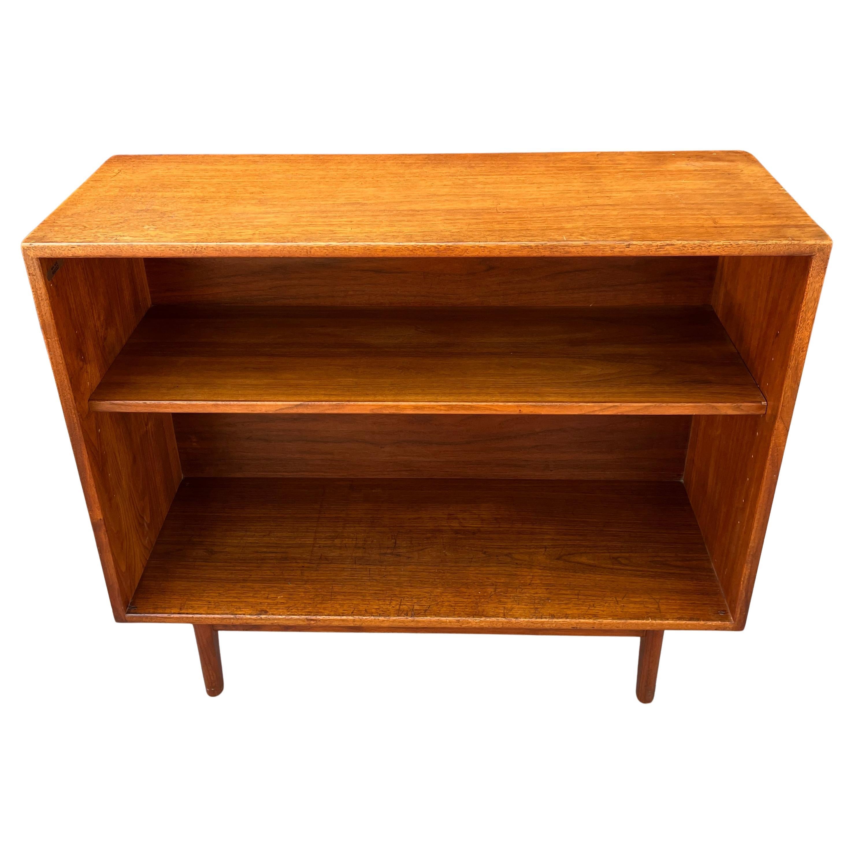 Gorgeous walnut bookcase by Danish American designer Jens Risom. Its sturdy, functional design is paired with a rich and vibrant wood grain. The bookcase sits atop a beautiful sculptural base and has original and honest patina, height adjustable