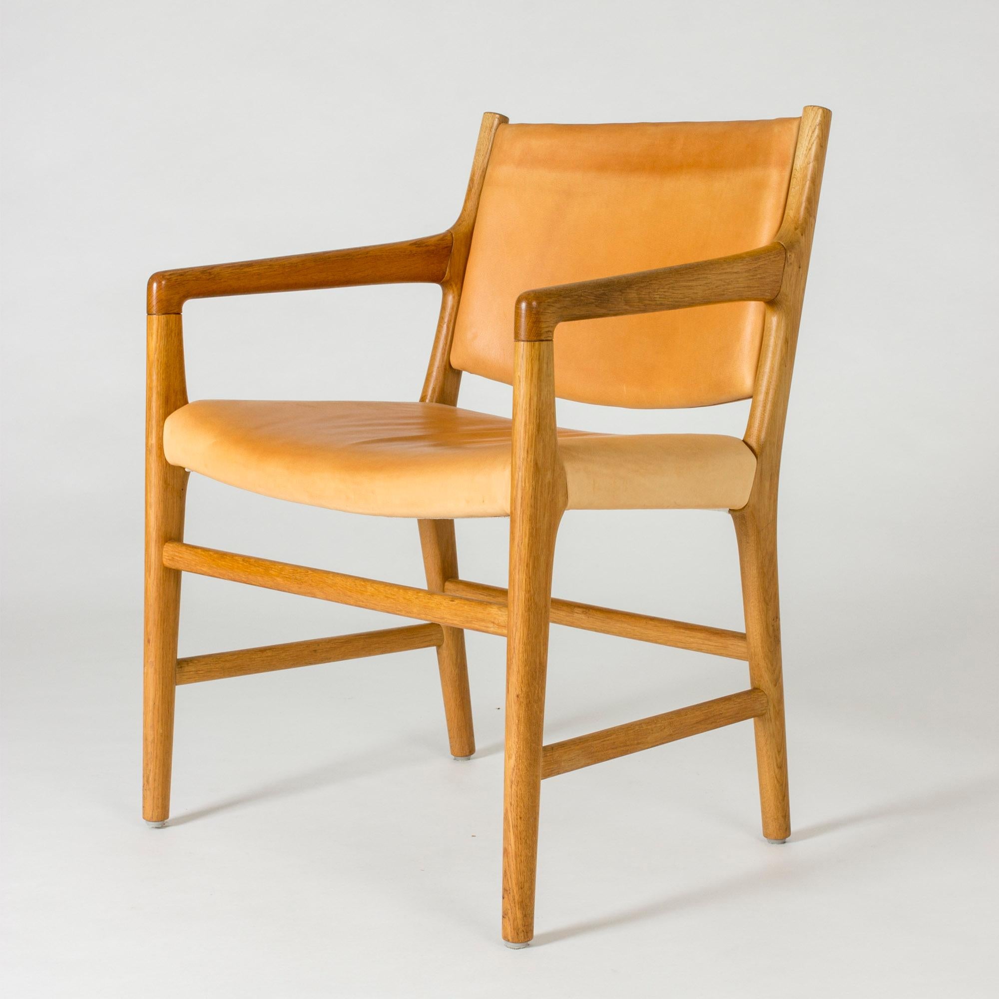 Elegant “JH 507” armchair by Hans J. Wegner, made with an oak frame and natural leather seat and back. Heavily patinated leather.