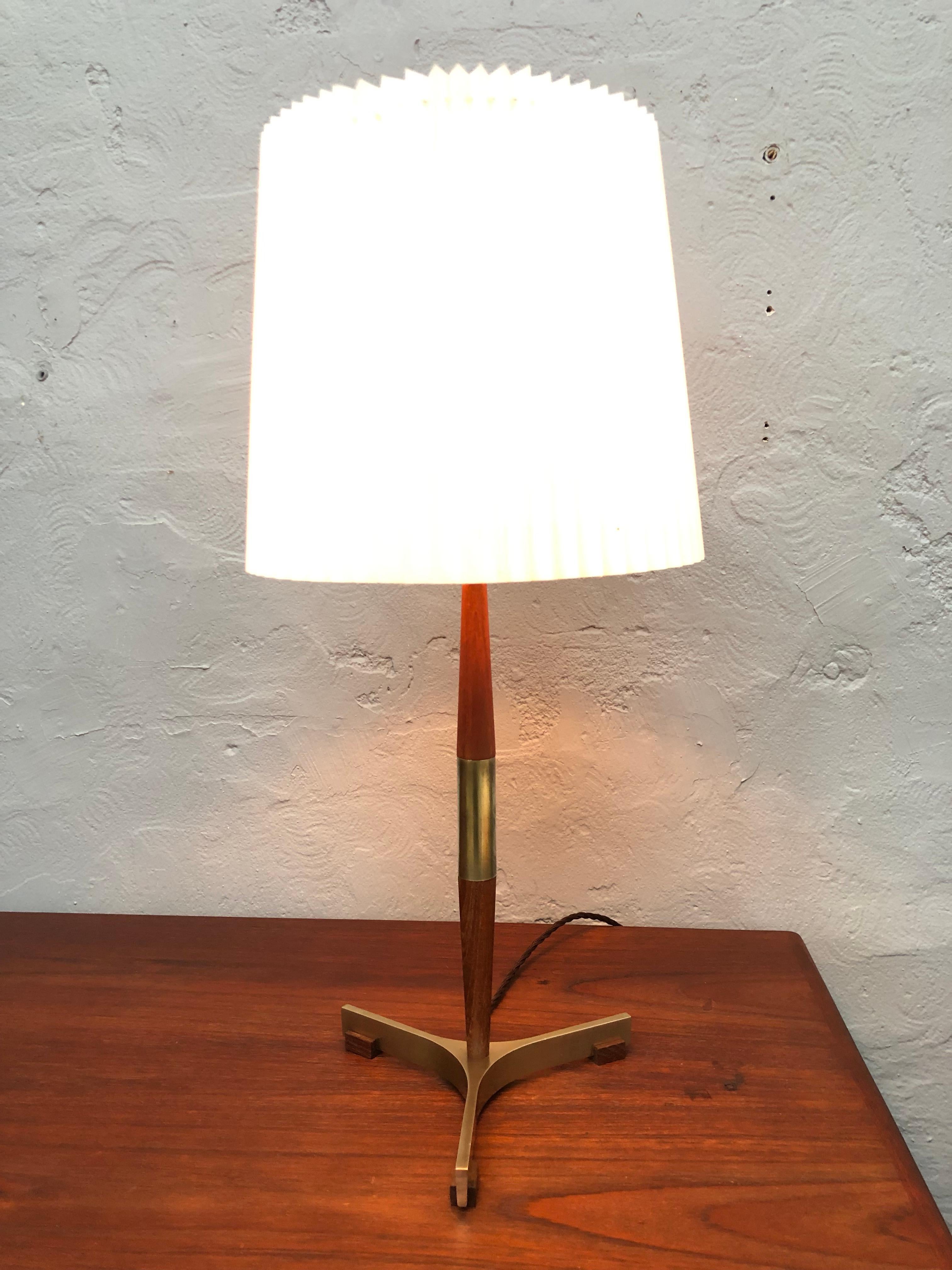Lampe de table iconique du président danois Jo Hammerborg pour Fog & Mørup en laiton et teck.
Base à trois pieds en laiton massif et pieds en teck.
Tige tournée en teck massif et laiton.
Recâblage avec un câble en tissu torsadé marron et mise à la