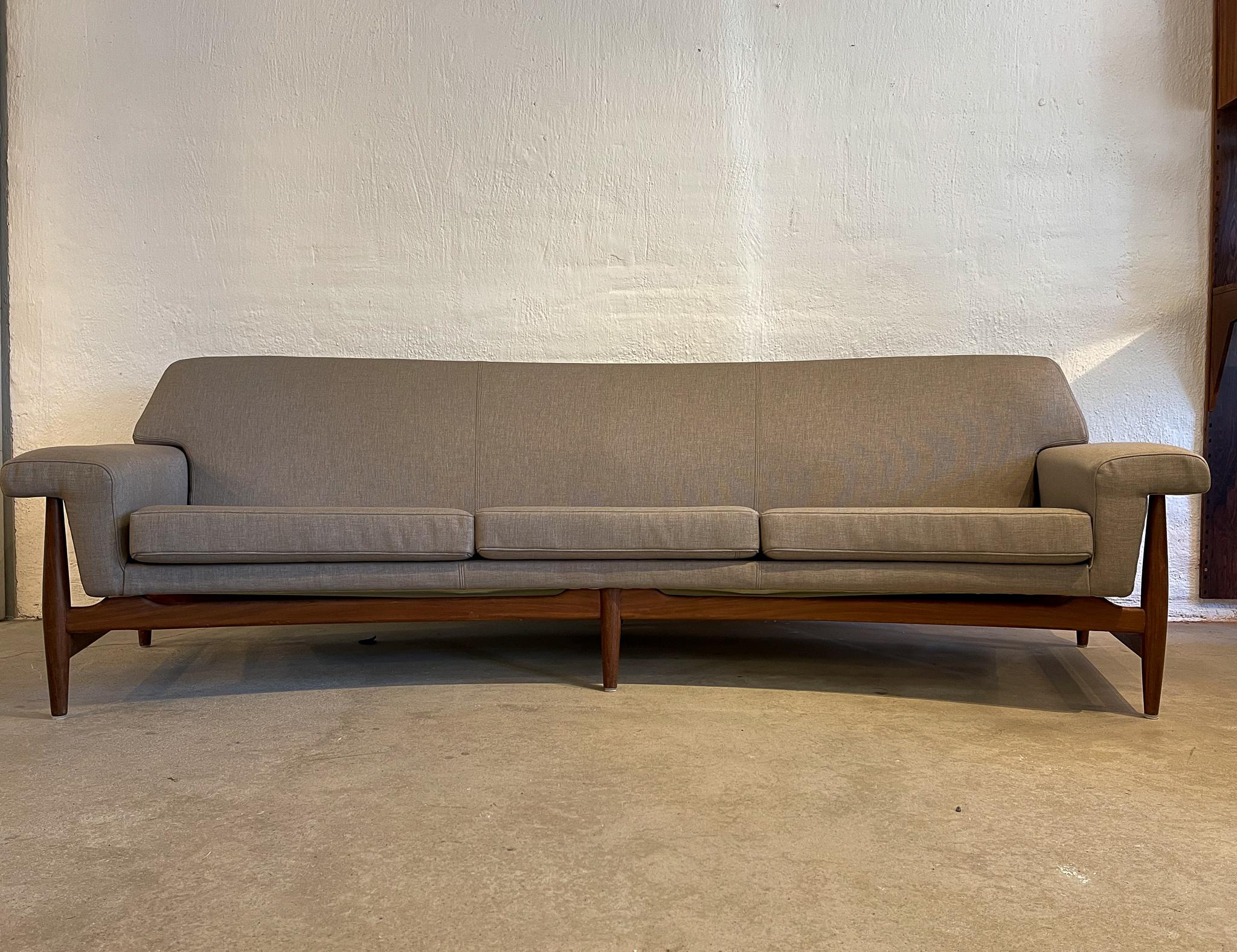 This Mid-Century Modern sofa was designed by famous creator and designer Johannes Andersen and manufactured at Trensum Møbelfabrik Sweden during the late 1950s. This curved sofa with all new quality upholstery textile and its solid teak frame gives