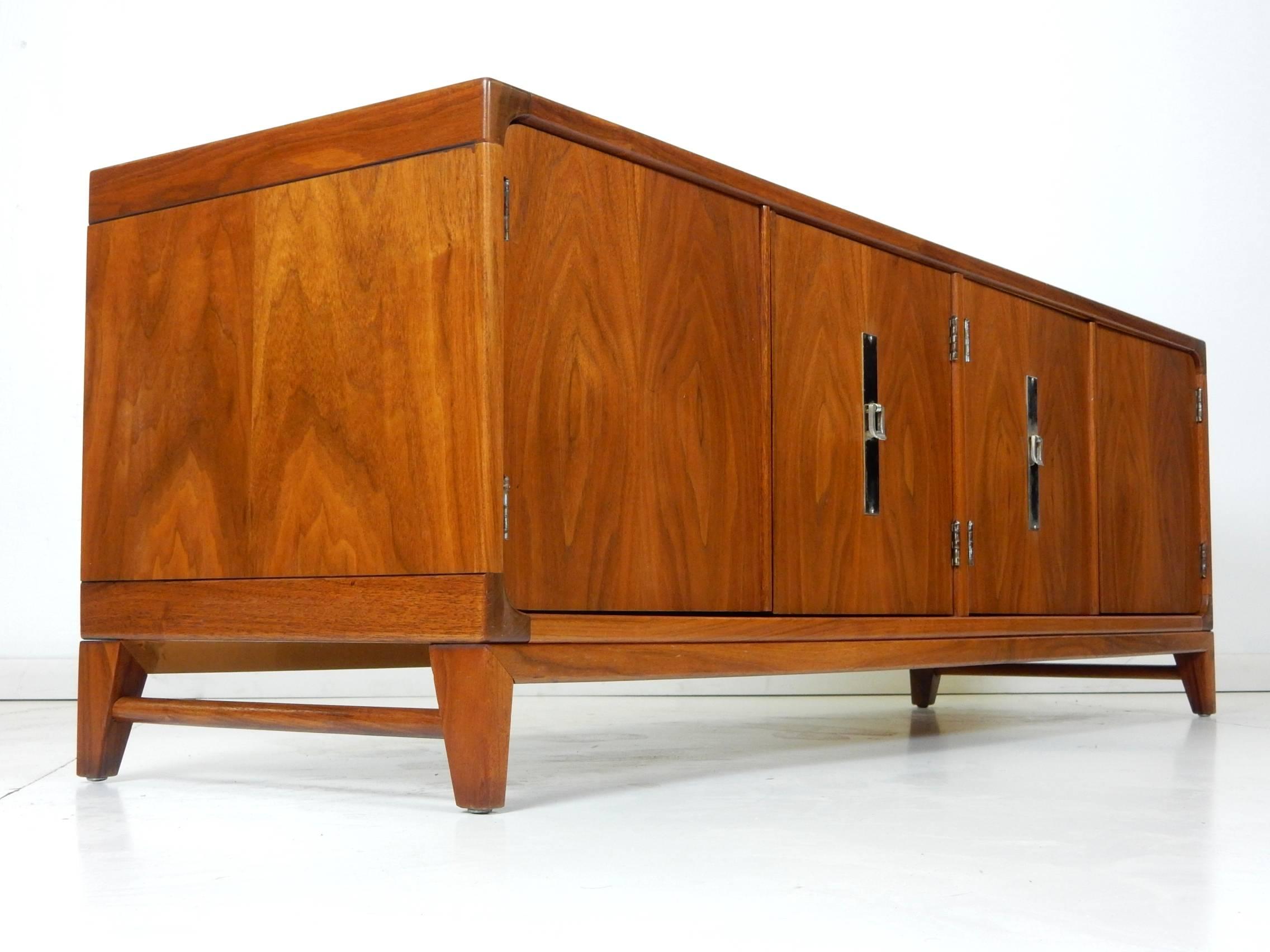 Incredible midcentury four-door cabinet designed by John Keal for Brown-Saltman.
Gorgeous walnut grain throughout. Nickel-plated pulls and back plate.
Exceptionally versatile piece of furniture which could be used as a bench, entry way cabinet or