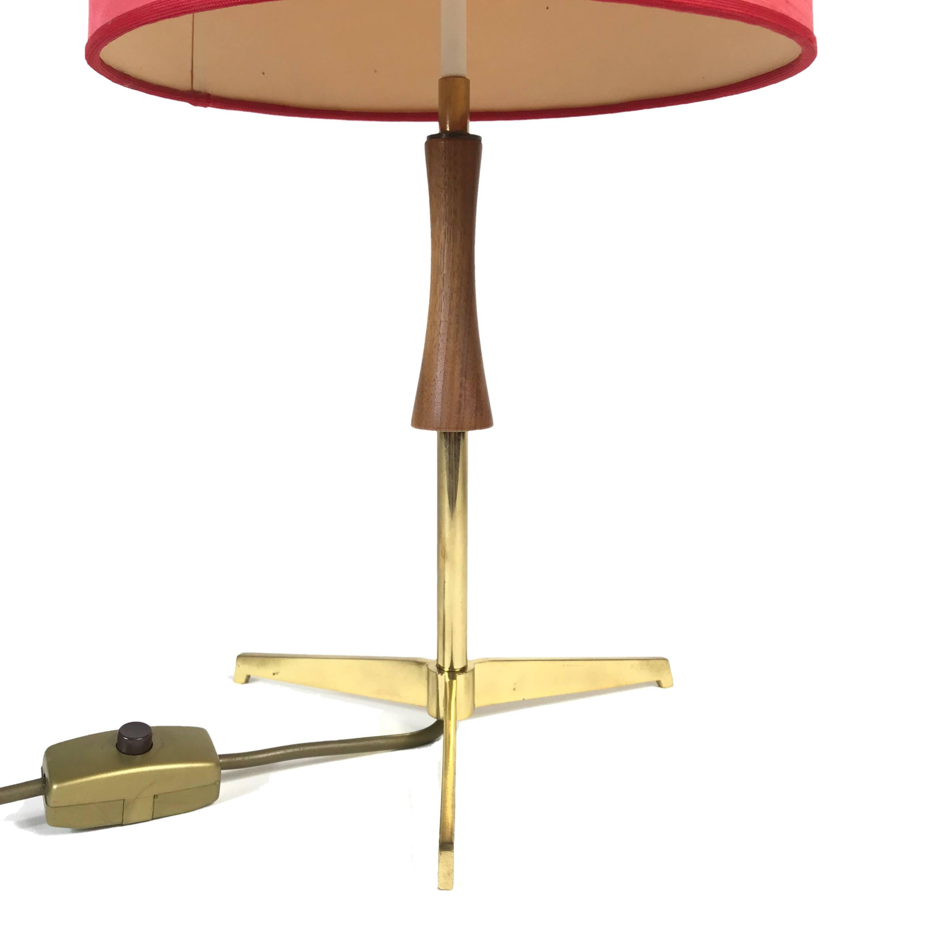 Simple and elegant midcentury table lamp manufactured by J.T. Kalmar in Vienna. The lamp is made of brass with wooden handle and has a polished brass tripod base. The red shade provides a smooth large-area light. The lamp is in excellent condition