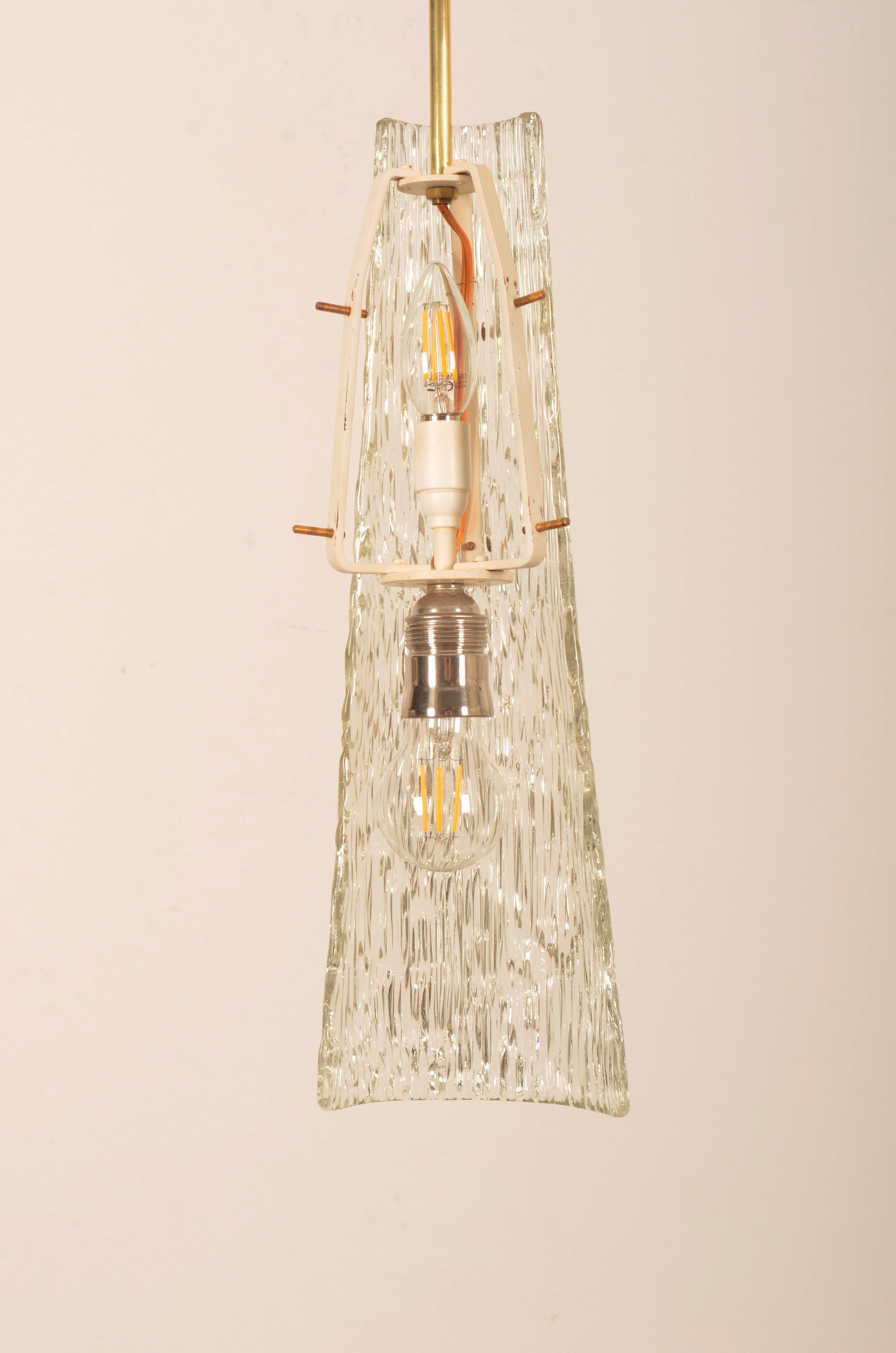 Brass frame fitted with one E27 and one E14 socket 3 crystal-ice structured glass elements. Designed by J.T. Kalmar in the 1950''s.
Total lenght 115cm, lenght of the lamp only 58cm.