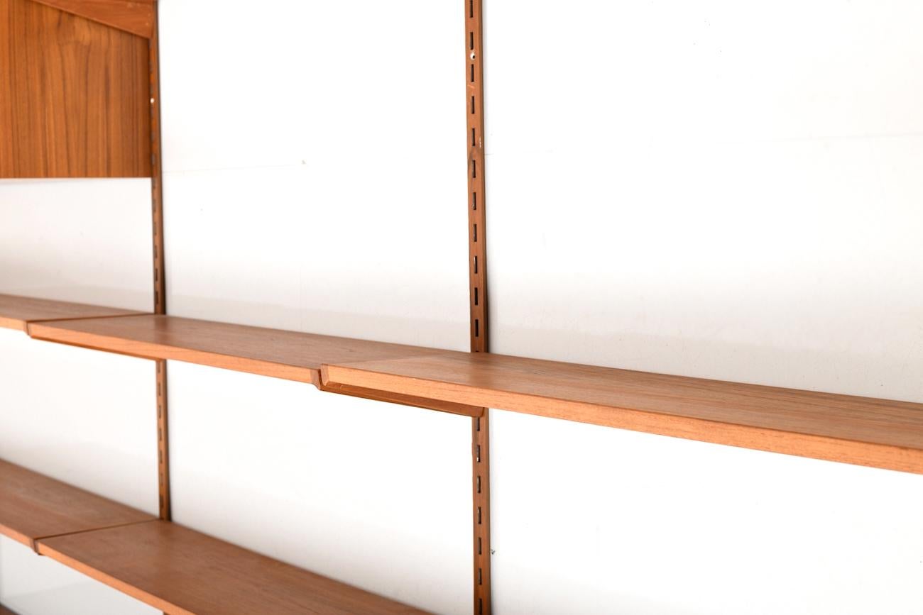 Midcentury Danish Kai Kristiansen wall or shelf system in teak. Manufactured by FM Feldballe.
Eight shelfes
Four cabinet (one with glass doors)
Four wall brackets

Size:
46.0 x 257.5 x 241.0 (wall brackets) CM (D x W x H)

Very good vintage