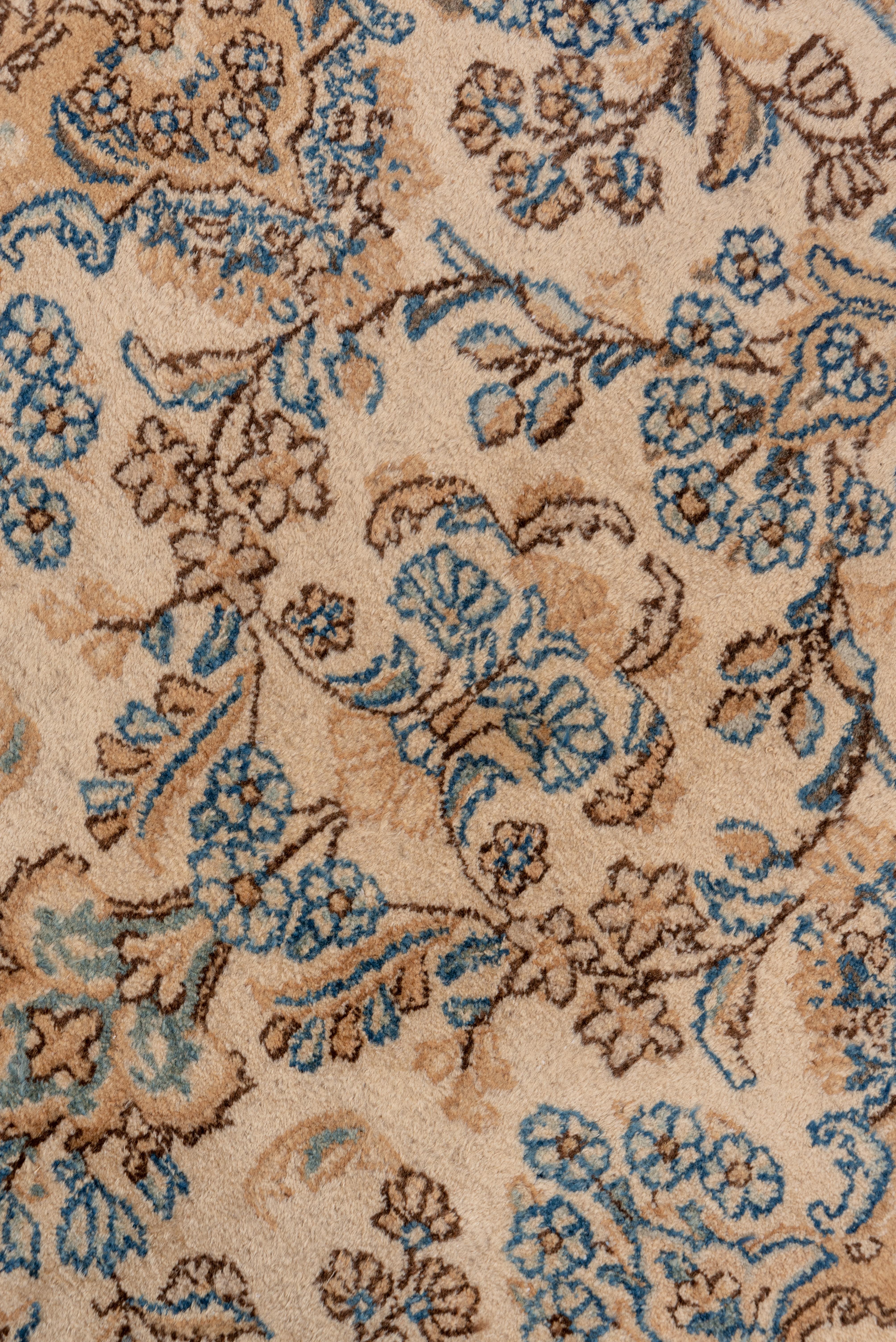 This ivory ground SE Persian city runner displays a detached flower spray pattern in light blue, sienna brown, pistachio, buff, salmon and tan, all within a same-colored broken border featuring flower head arrays.