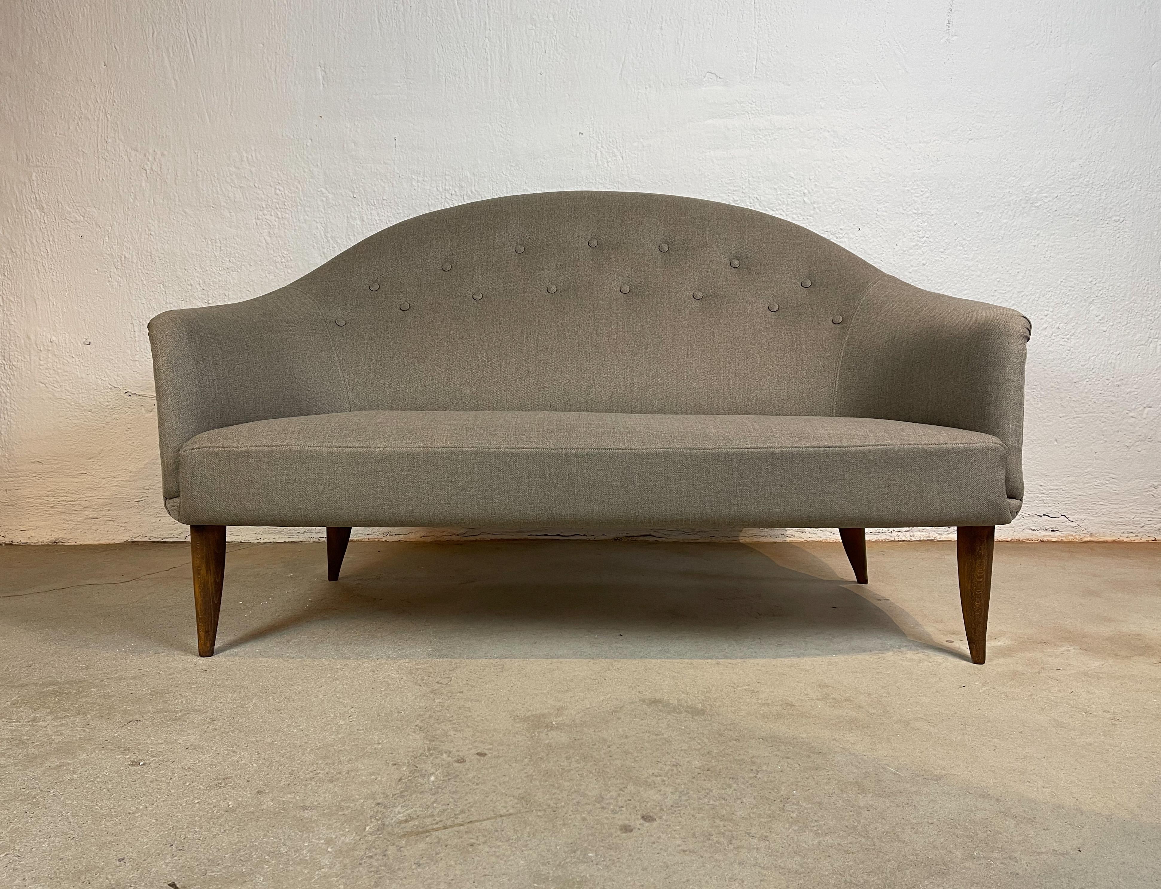 This two-seat sofa with elegant and sensual forms was named “Paradiset” and was a series designed by Kerstin Hörlin-Holmquist for NK (Nordiska Kompaniet), 1958. Reupholstered with Swedish quality fabric and the birch legs are stained with a