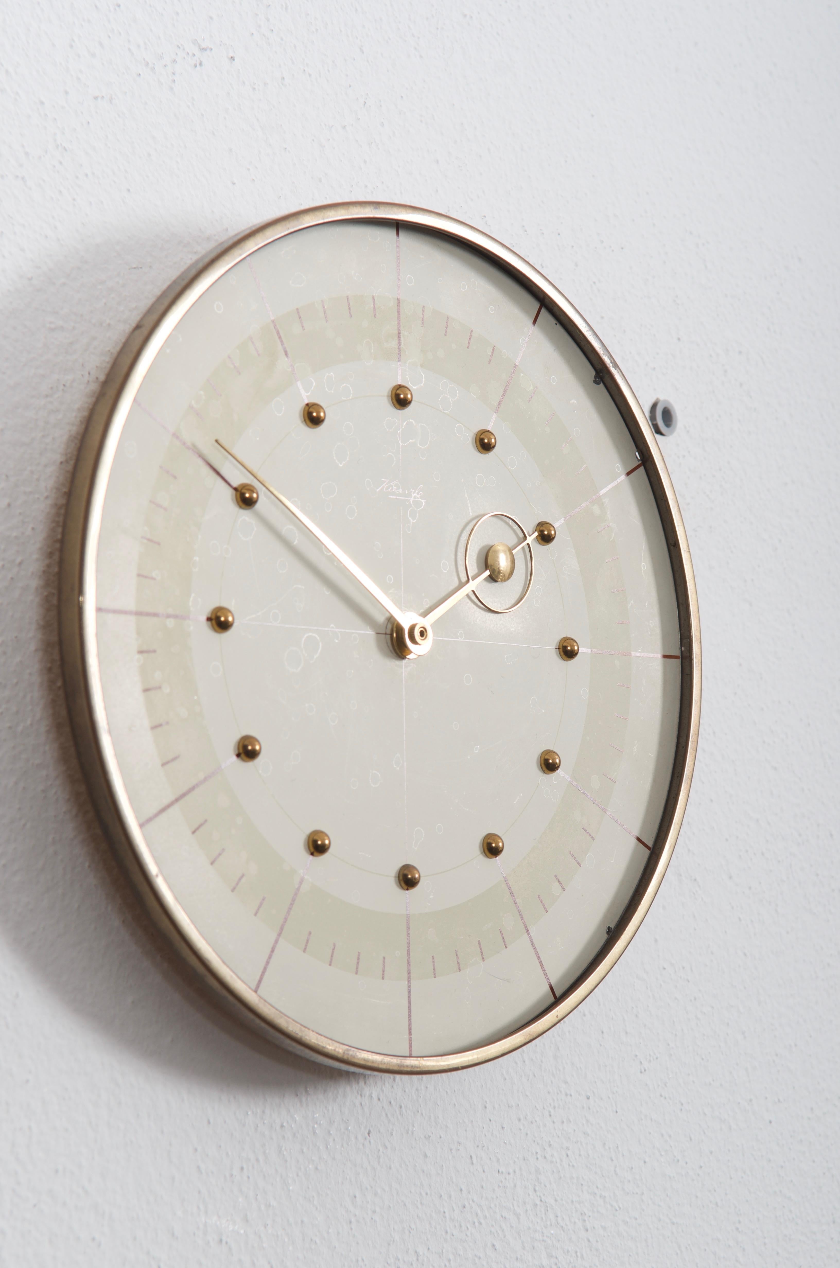 Aluminum clock face and brass hands made by Kienzl in the late, 1950s. Fitted with a modern quartz movement with a battery.
   