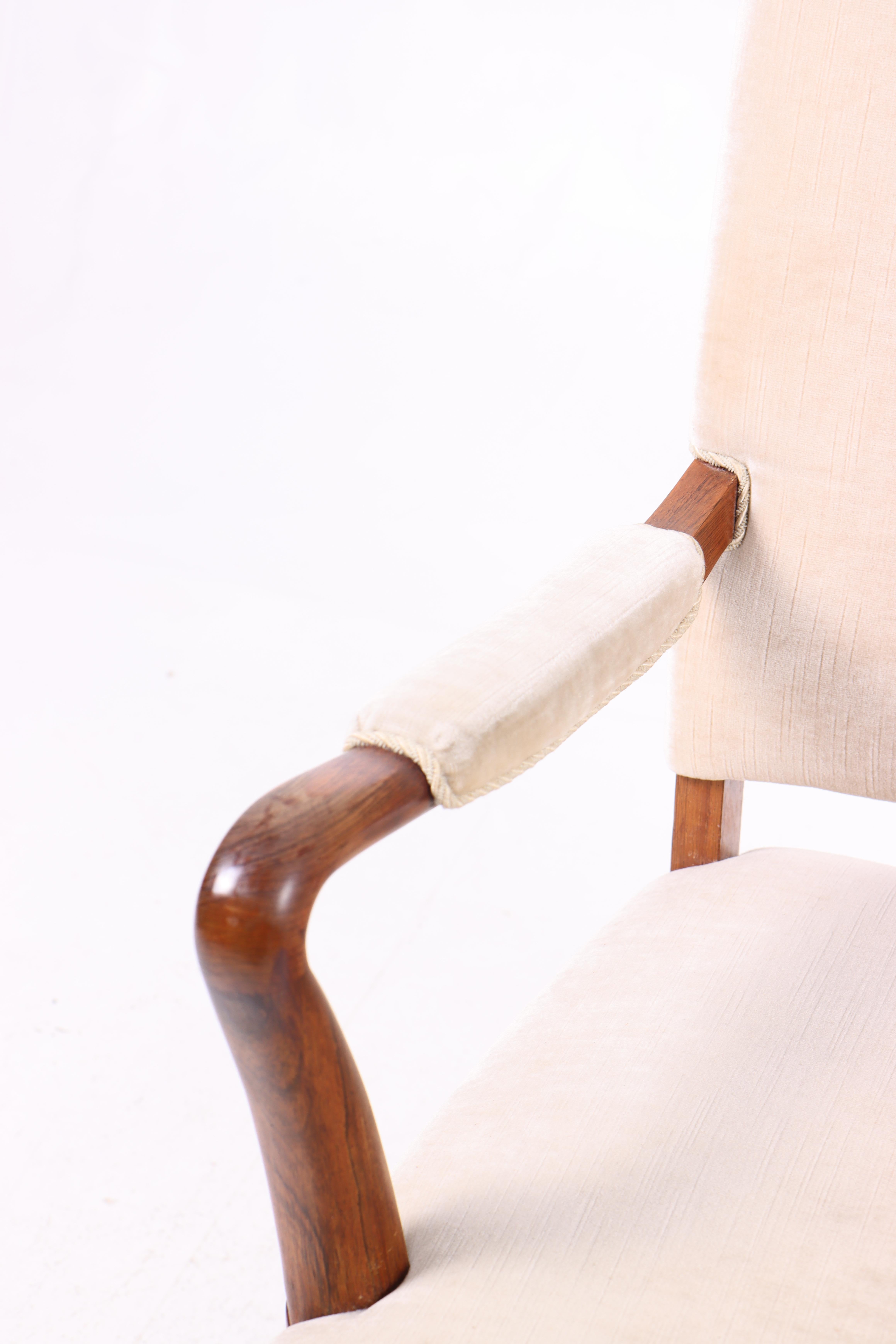 Fauteuil danois avec de beaux détails en bois de rose et tissu. Ce fauteuil n'est pas seulement fonctionnel, c'est aussi une belle pièce de design qui peut s'intégrer dans de nombreux styles d'intérieur.
Parfait pour le salon, le bureau ou comme