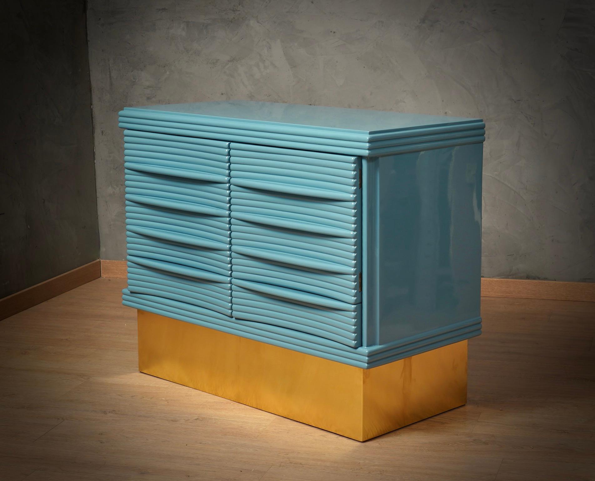 Credenza unica nel suo genere per originalità e scelta dei materiali. Design semplice ma raffinato, da notare le nervature in legno lucido che ricoprono le ante della credenza. Nota il ricco design delle ante e il piede in ottone che solleva la