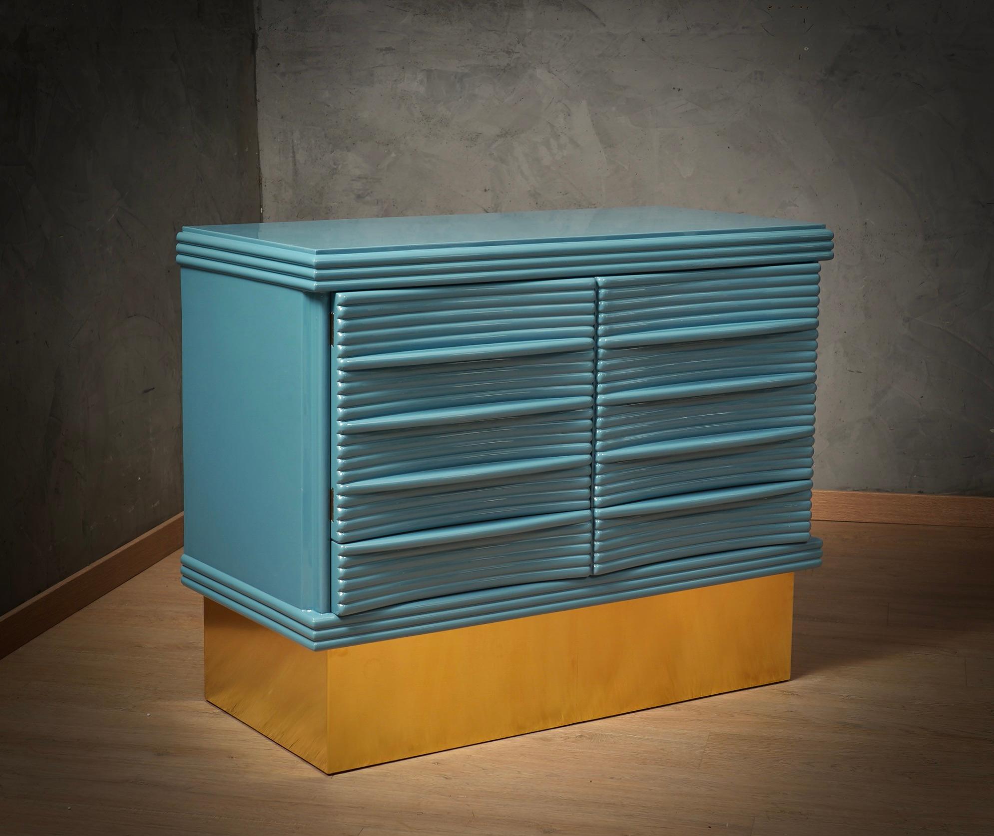 Sideboard unique in its kind for originality and choice of materials. Simple but refined design, note the polished wooden ribbing that covers the doors of the sideboard. Note the rich design of the doors and the brass foot that raises the sideboard