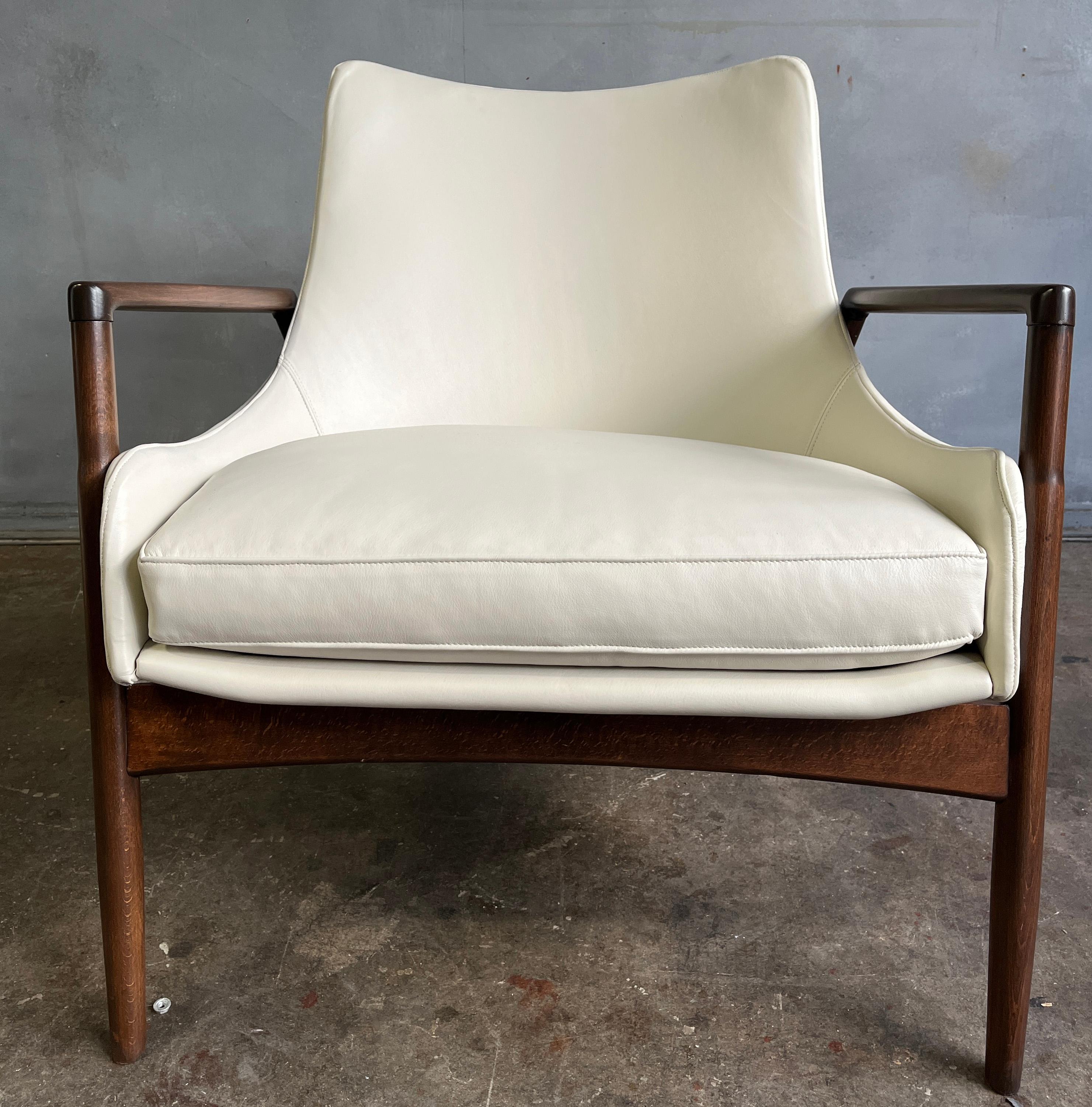 Stunning pair of Danish leather lounge chairs designed by Ib Kofod-Larsen for Selig. Expert craftsmanship put into making this design. Both chairs have been refinished, new webbing, and reupholstered in high quality off-white leather.