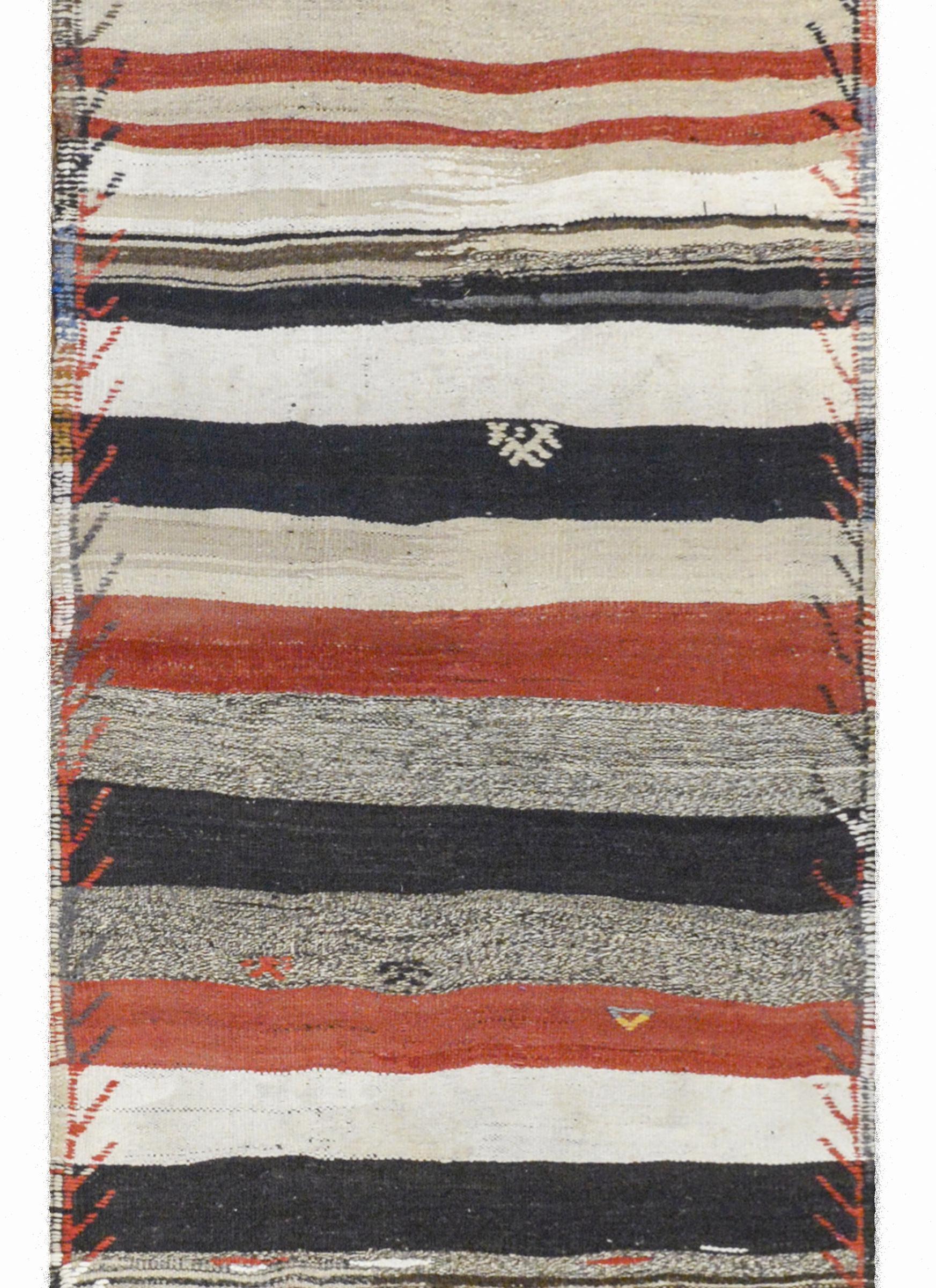 A fantastic mid-20th century Turkish Konya Kilim runner with alternating crimson, black, white, and gray stripes with embroidered stylized flowers and an embroidered border.