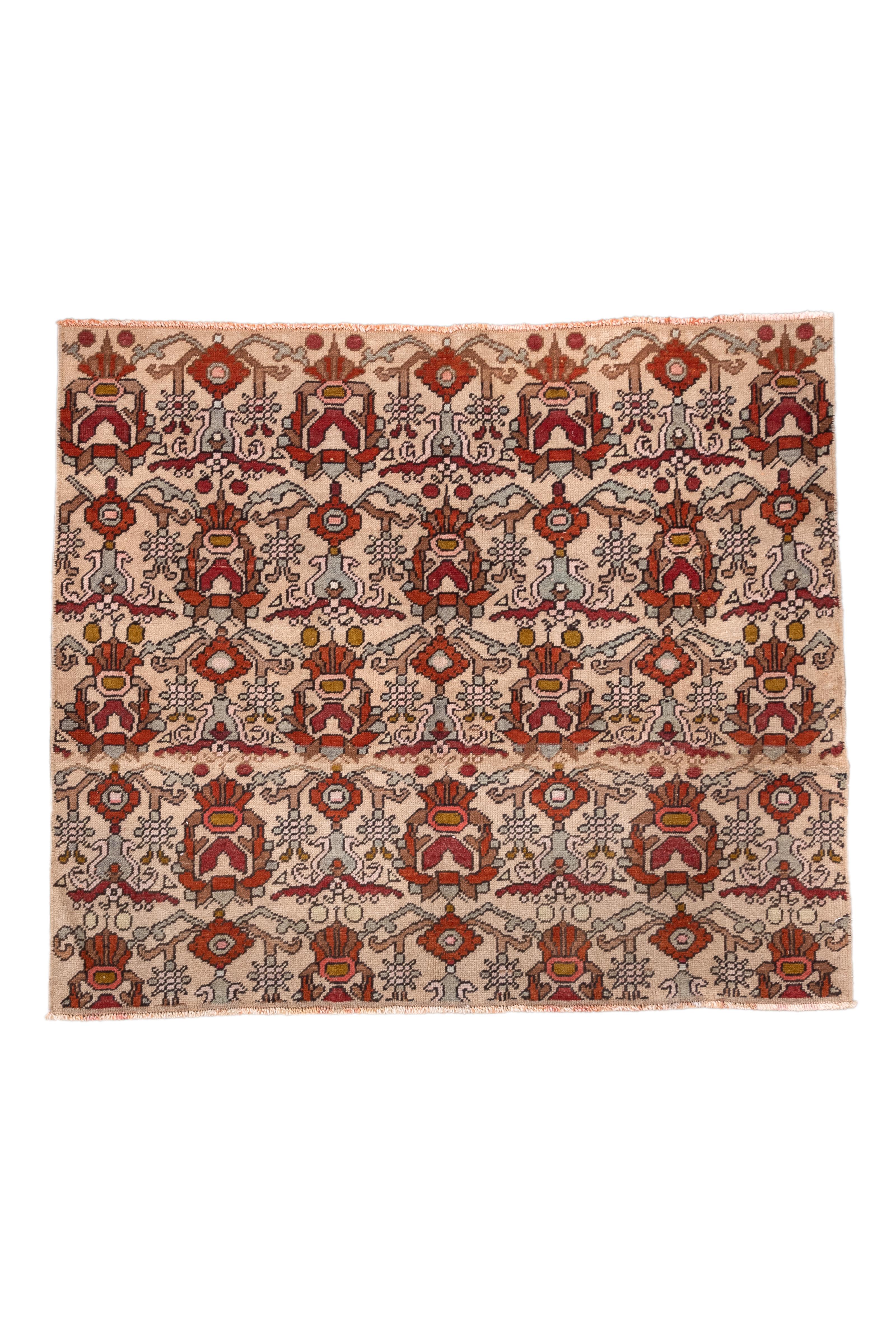 Tapis Konya du milieu du siècle, audacieux et énergique, présentant des motifs tribaux stylisés en rangées répétées. La palette comprend des nuances frappantes de rouge brique, de jaune moutarde, de brun chocolat et de lavande sur un fond ivoire