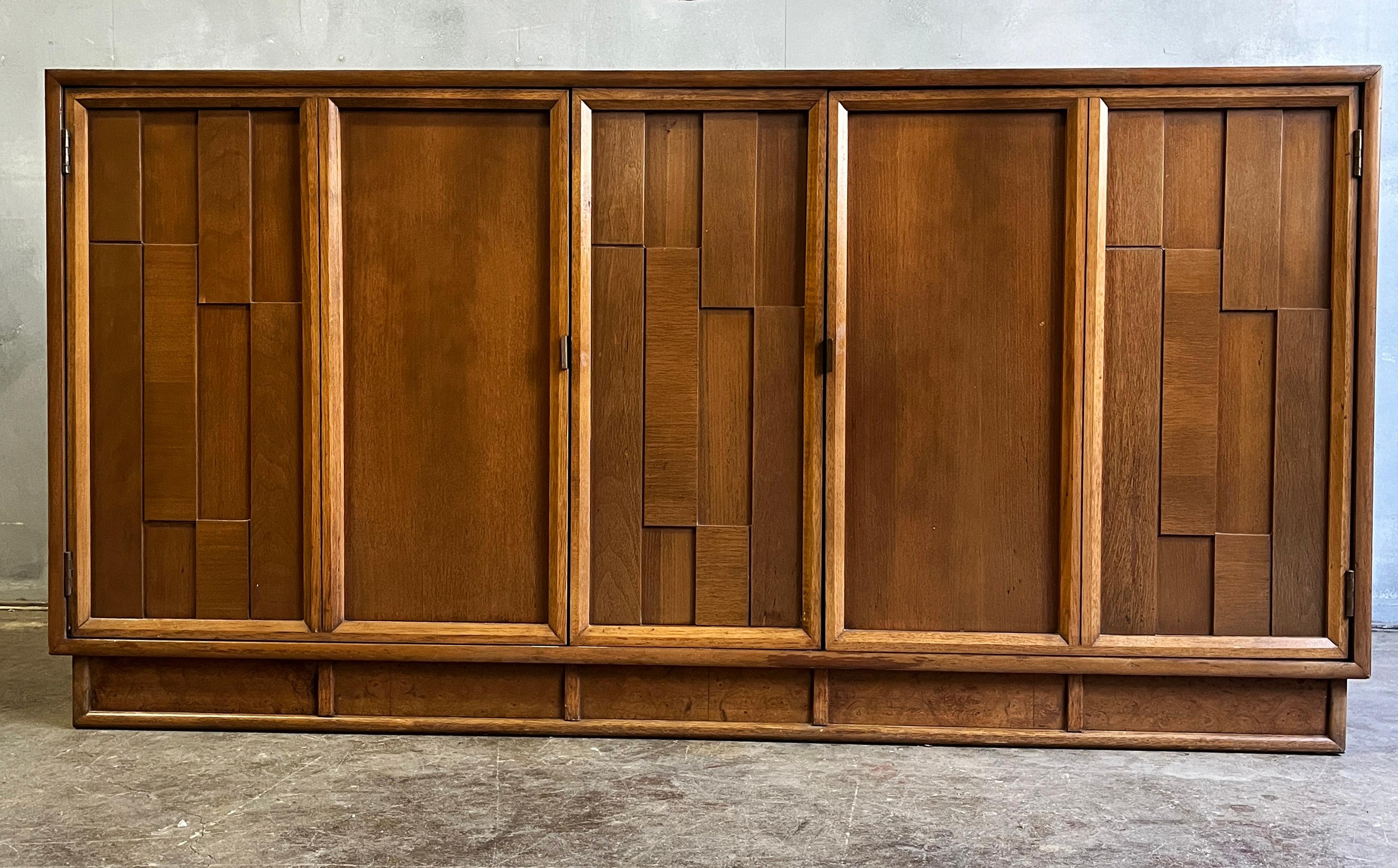 Solid soft Brutalist cabinet executed in walnut on a plinth. Featuring swing open doors revealing three shelves and open shelf. Great size and style. 

Ask for custom shipping quote. Local pickup always free. Paul Evans style